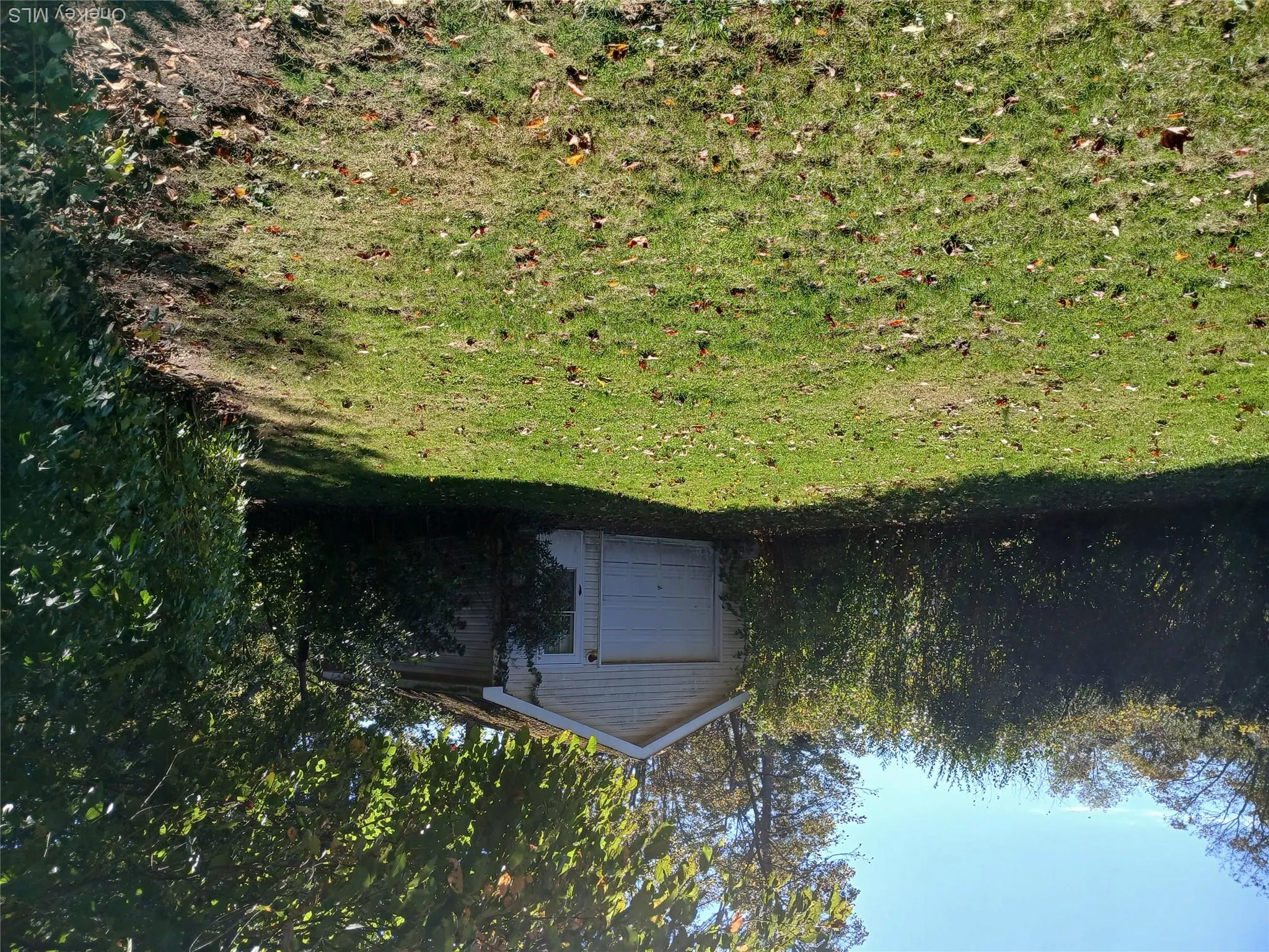 View of green lawn featuring an outdoor structure and a garage View of green lawn featuring an outdoor structure and a garage