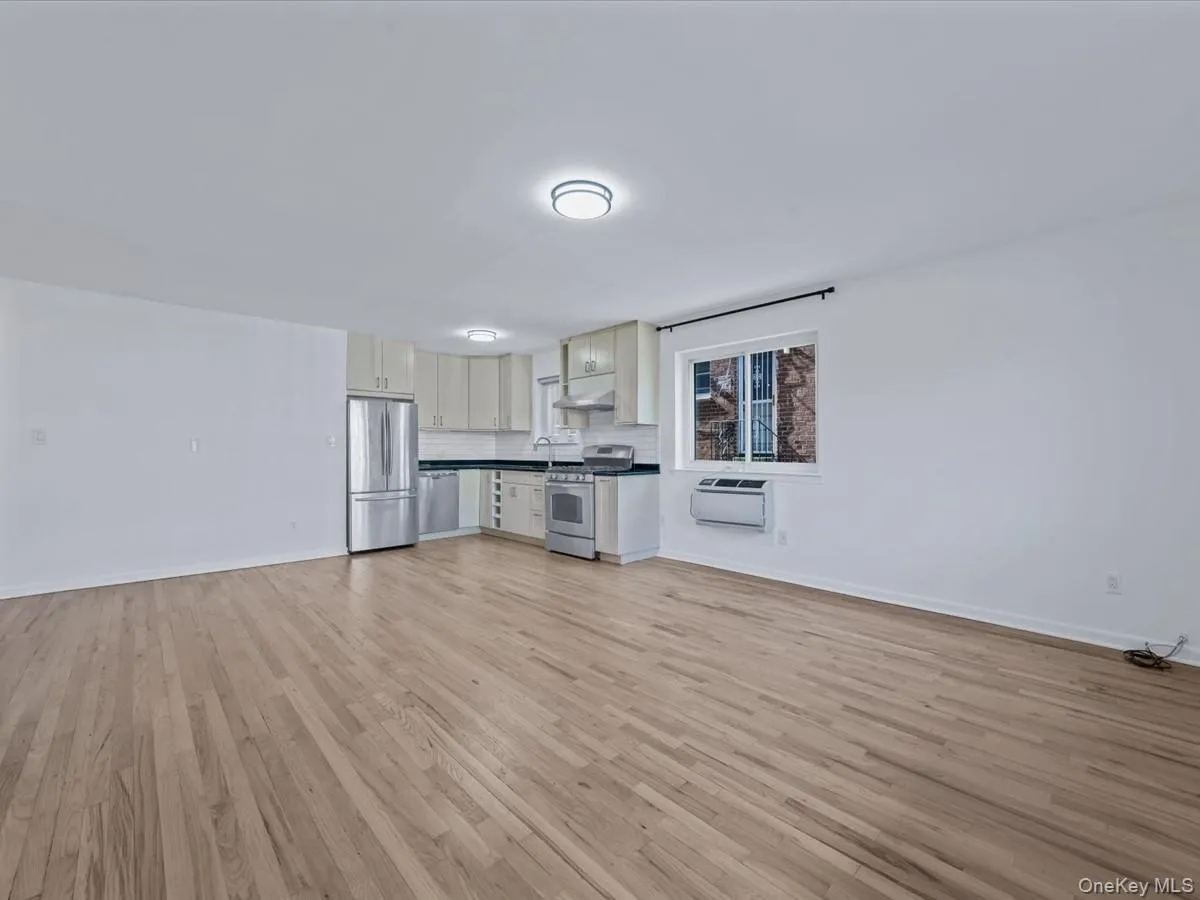 Unfurnished living room with baseboards and light wood-type flooring Unfurnished living room with baseboards and light wood-type flooring