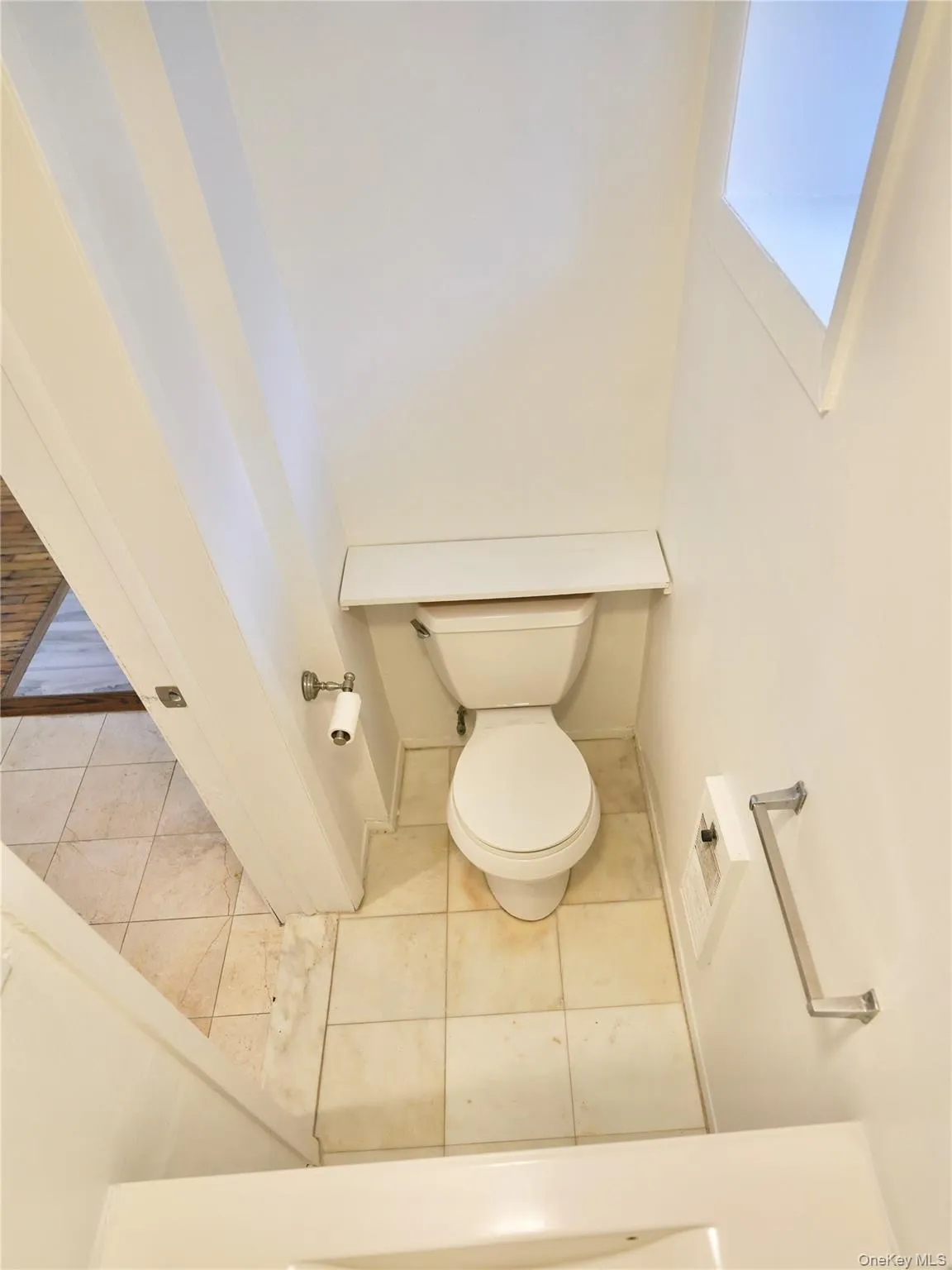 Bathroom featuring tile patterned flooring and toilet Bathroom featuring tile patterned flooring and toilet