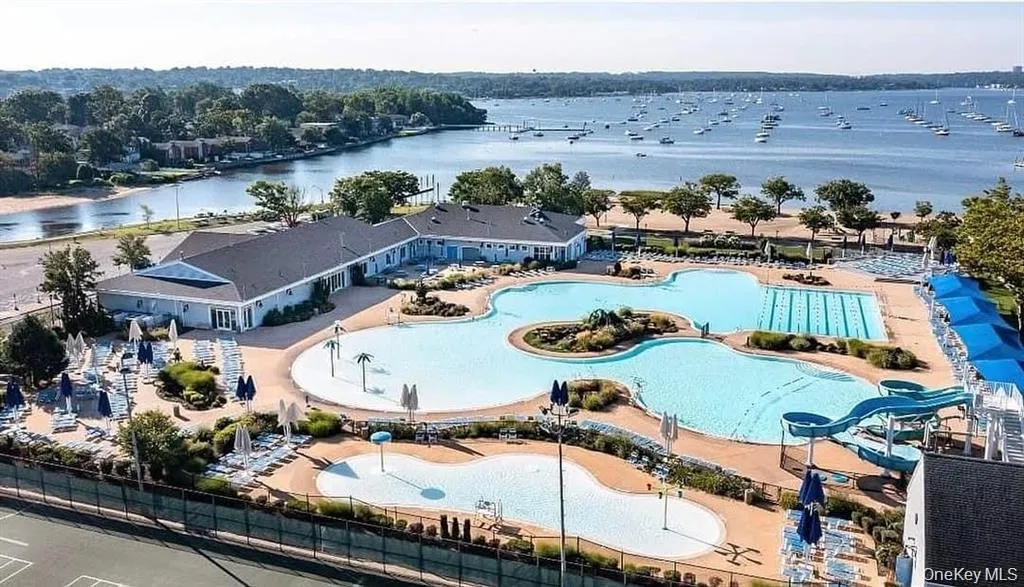 Aerial view of a nearby body of water and a pool area Aerial view of a nearby body of water and a pool area