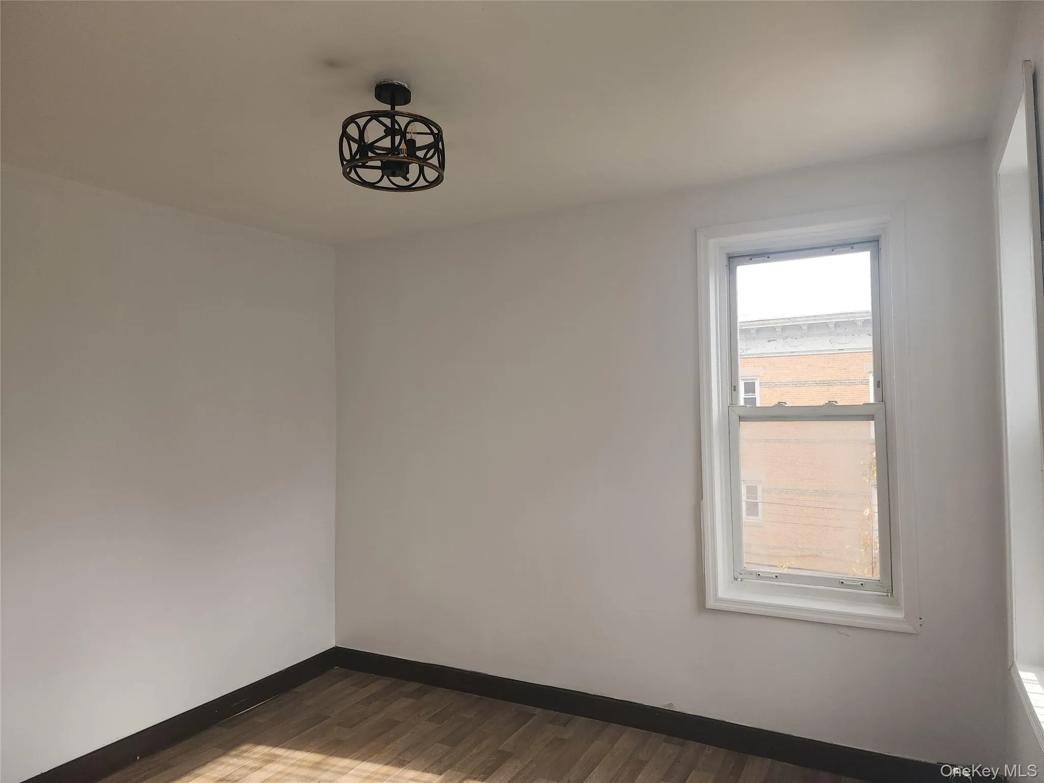 Empty room featuring baseboards and dark wood-style floors Empty room featuring baseboards and dark wood-style floors