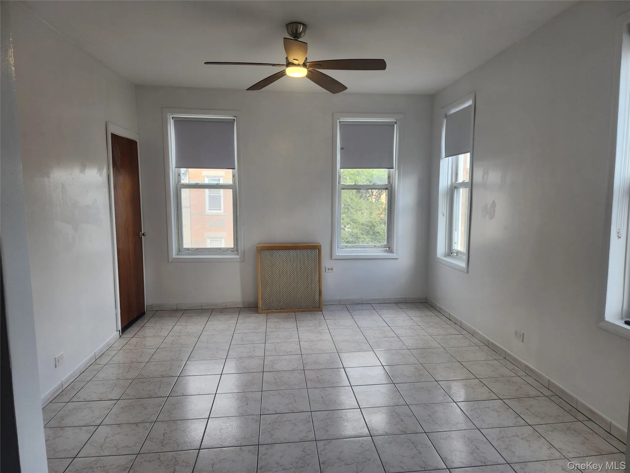 Spare room featuring ceiling fan and light tile patterned floors Spare room featuring ceiling fan and light tile patterned floors