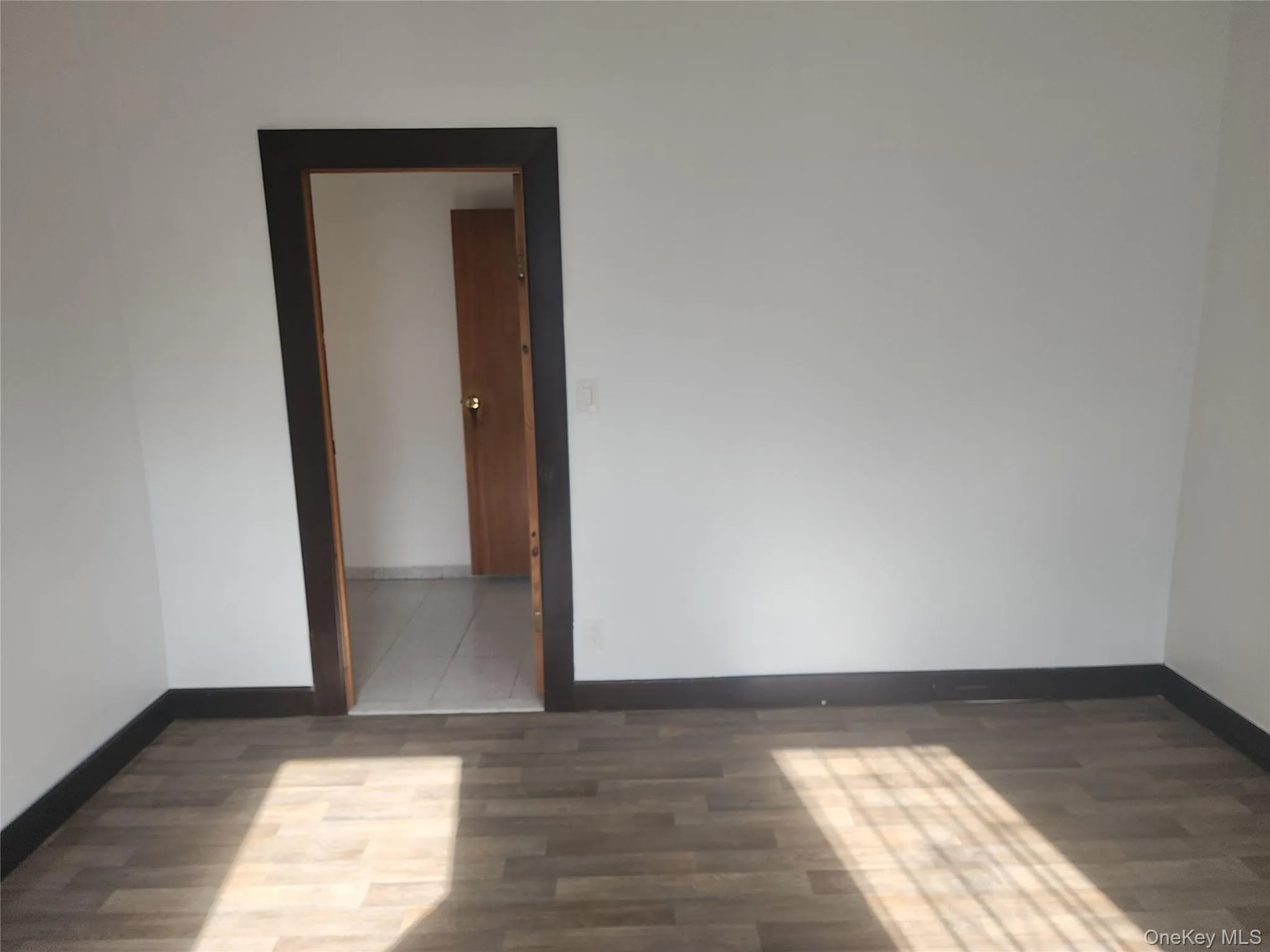 Empty room with baseboards and wood finished floors Empty room with baseboards and wood finished floors