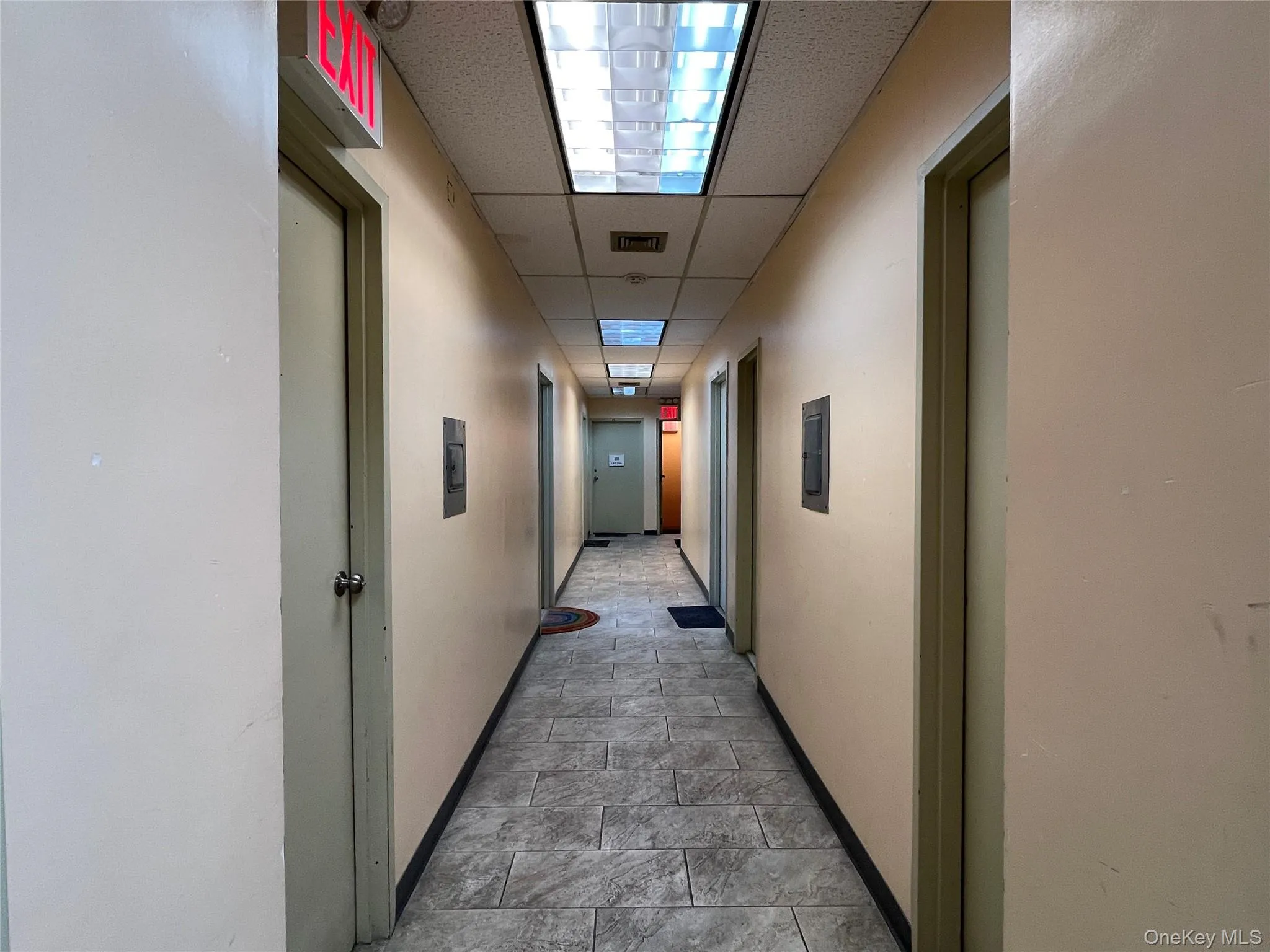 Hall featuring a drop ceiling and stone finish floors Hall featuring a drop ceiling and stone finish floors