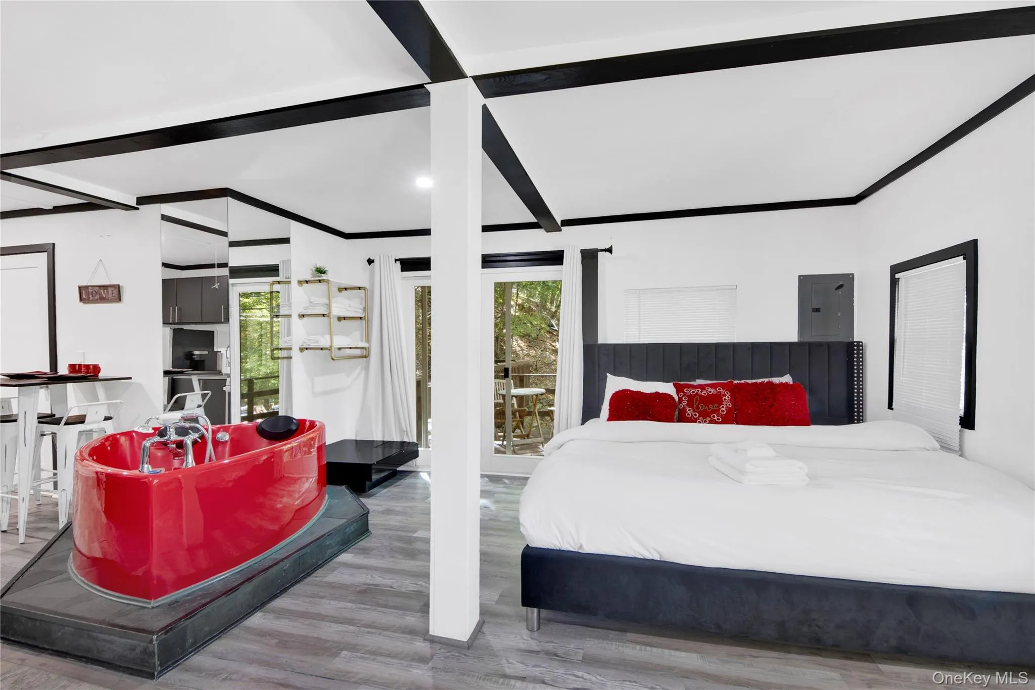 Bedroom featuring wood finished floors, electric panel, crown molding, and beam ceiling Bedroom featuring wood finished floors, electric panel, crown molding, and beam ceiling