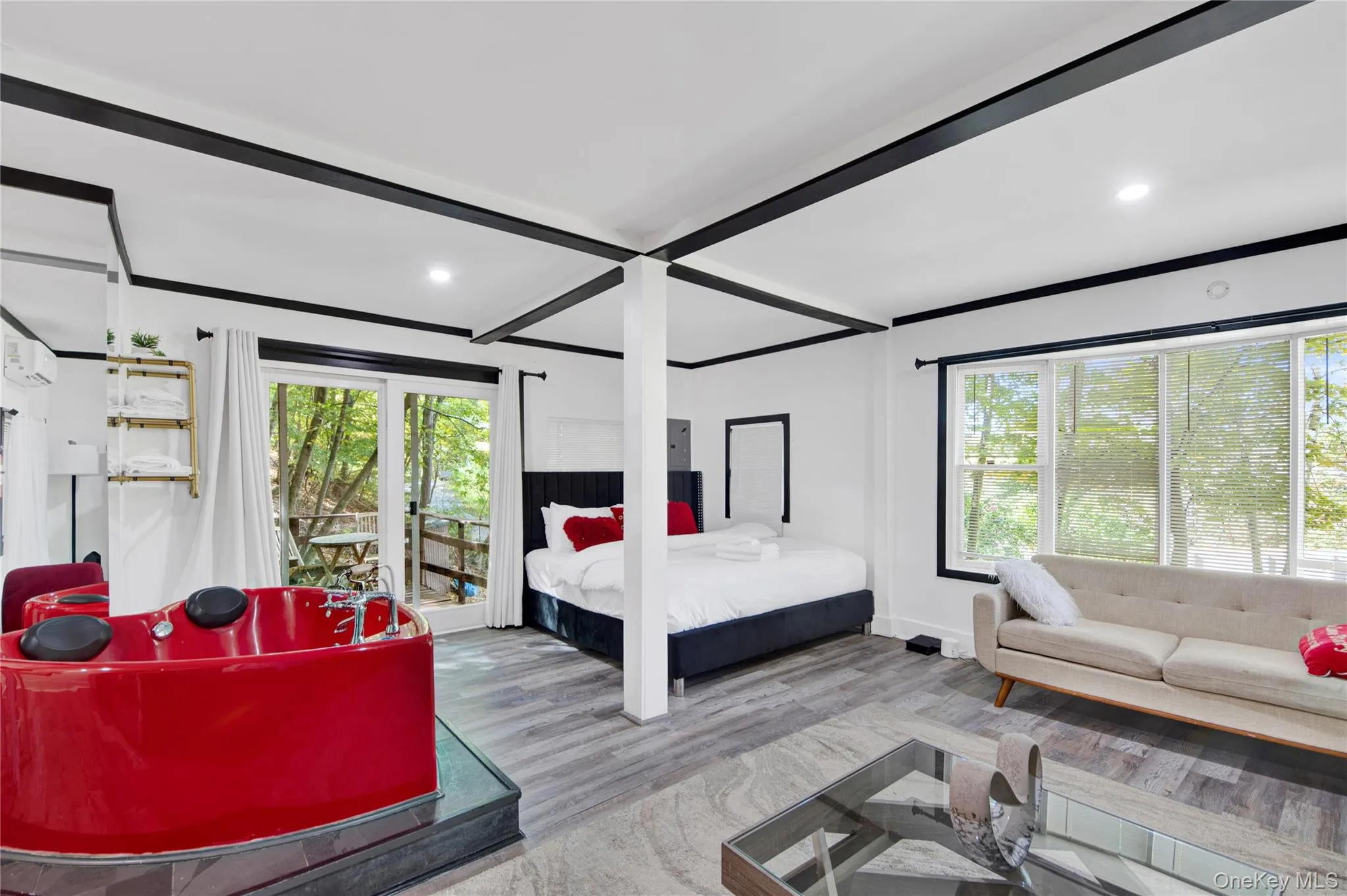 Bedroom featuring multiple windows, access to outside, wood finished floors, beam ceiling, and recessed lighting Bedroom featuring multiple windows, access to outside, wood finished floors, beam ceiling, and recessed lighting