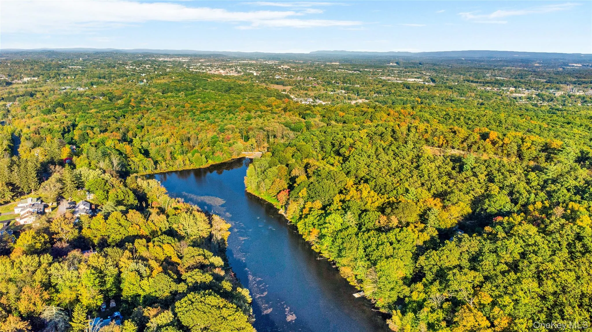 Bird's eye view of a nearby body of water and a heavily wooded area Bird's eye view of a nearby body of water and a heavily wooded area