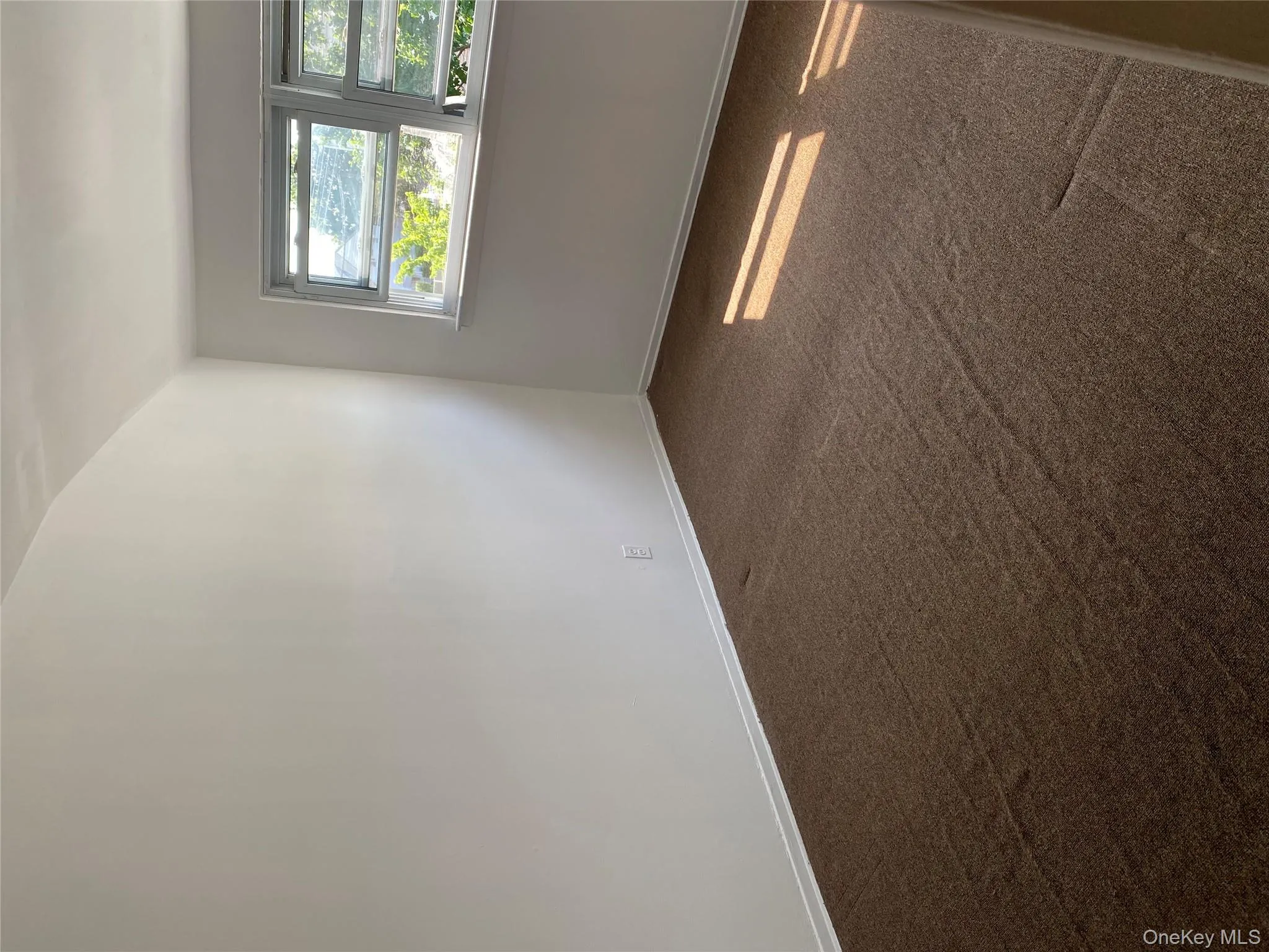 Unfurnished room featuring dark carpet and baseboards Unfurnished room featuring dark carpet and baseboards
