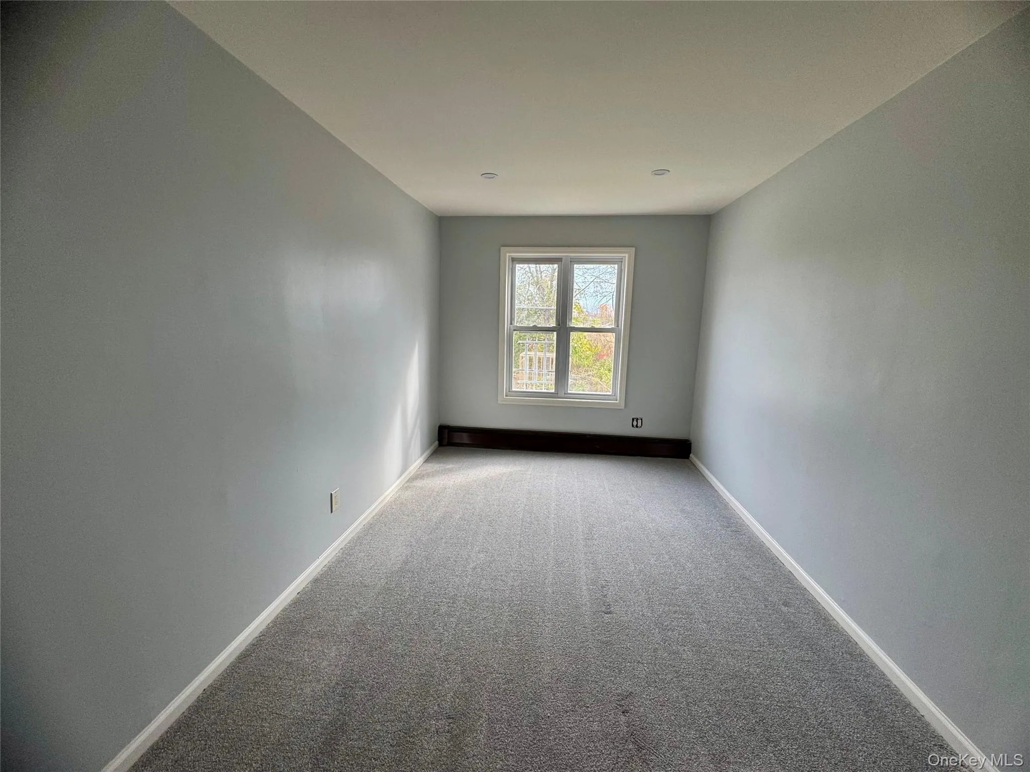 Second bedroom with carpet floors and baseboards Second bedroom with carpet floors and baseboards