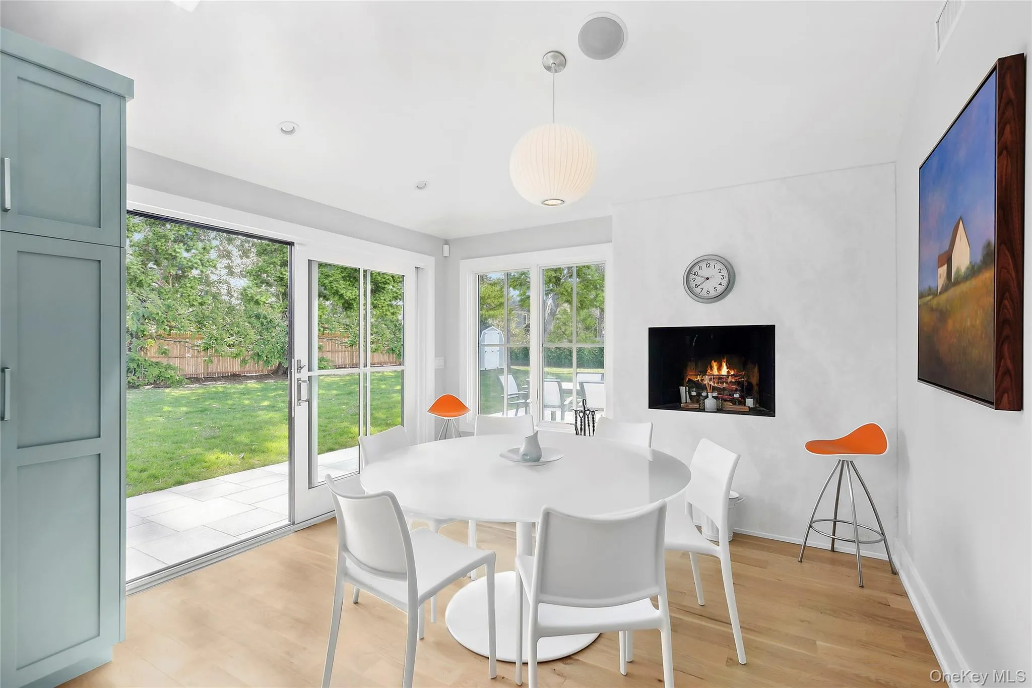 Dining room featuring light wood-style floors and a lit fireplace Dining room featuring light wood-style floors and a lit fireplace