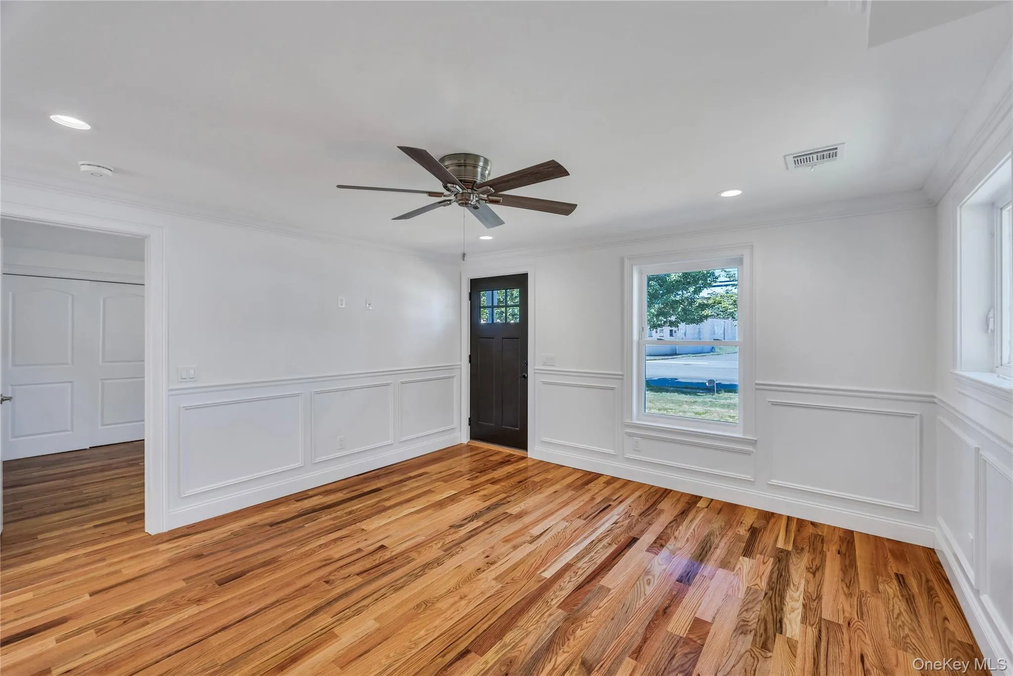 Unfurnished room featuring crown molding, light wood-style flooring, a ceiling fan, a decorative wall, and recessed lighting Unfurnished room featuring crown molding, light wood-style flooring, a ceiling fan, a decorative wall, and recessed lighting