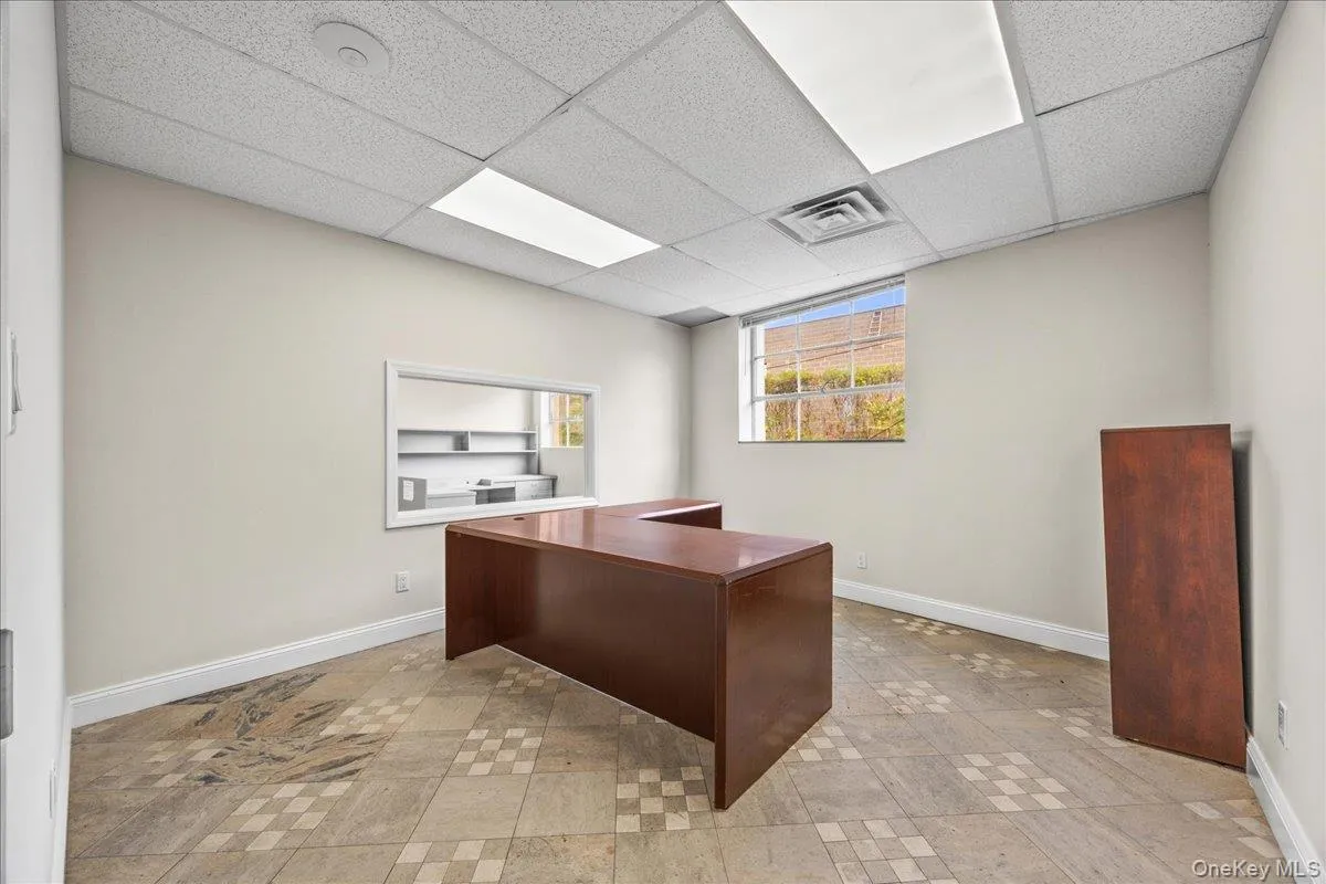 Office area with baseboards and a paneled ceiling Office area with baseboards and a paneled ceiling