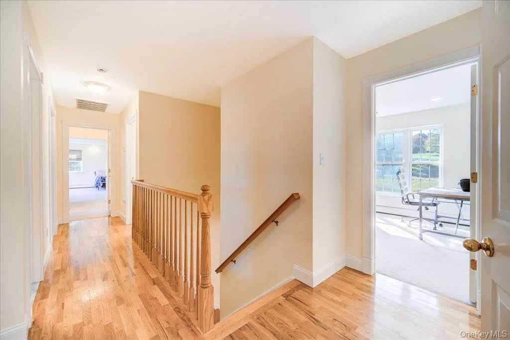 Hall with an upstairs landing and light wood-style flooring Hall with an upstairs landing and light wood-style flooring