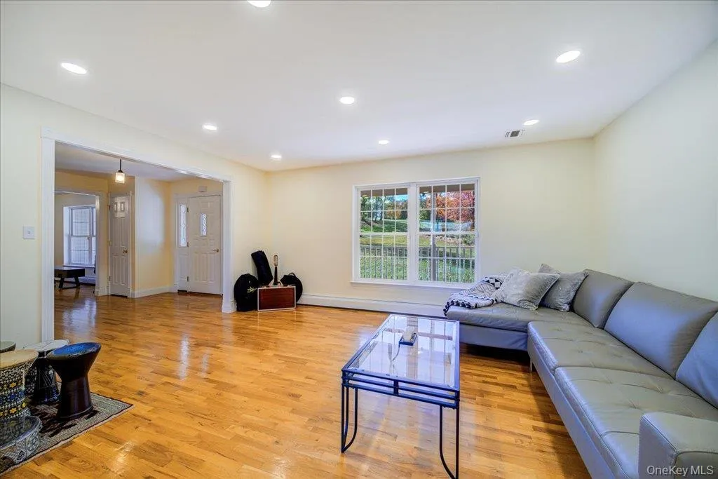 Living room featuring light wood flooring, recessed lighting, and a baseboard radiation Living room featuring light wood flooring, recessed lighting, and a baseboard radiation