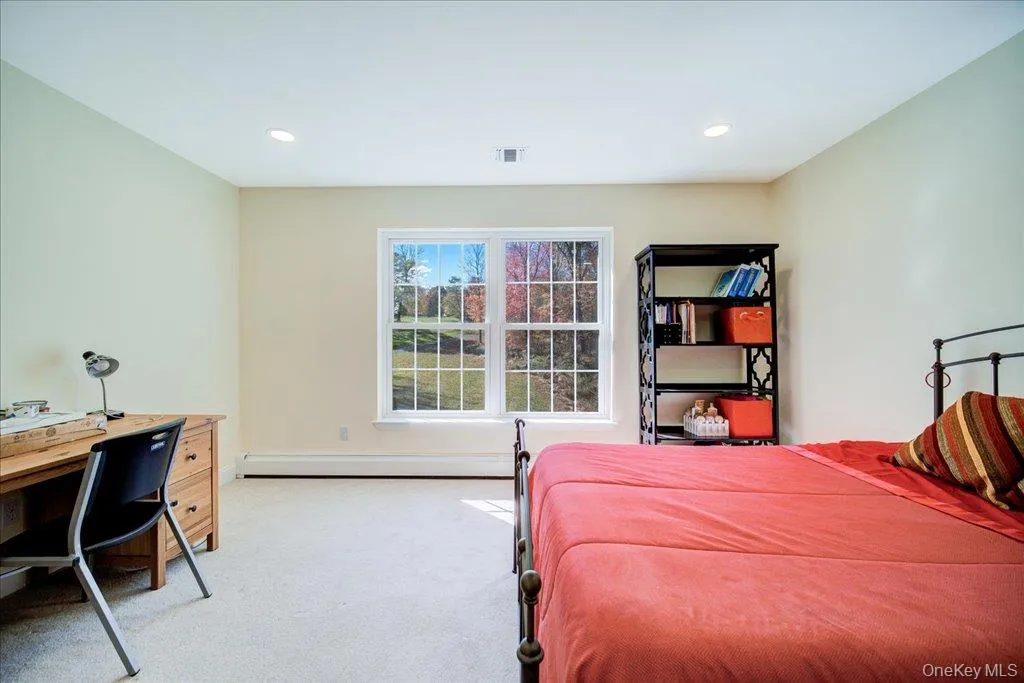 Bedroom featuring light carpet, a desk, baseboard heating, and recessed lighting Bedroom featuring light carpet, a desk, baseboard heating, and recessed lighting