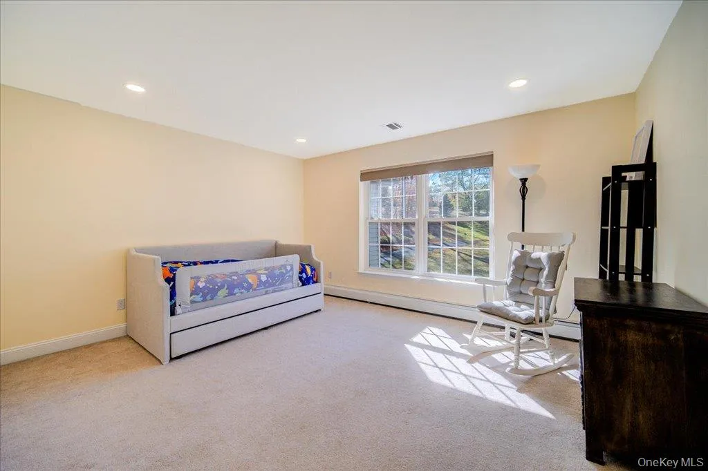 Carpeted bedroom featuring recessed lighting and a baseboard heating unit Carpeted bedroom featuring recessed lighting and a baseboard heating unit