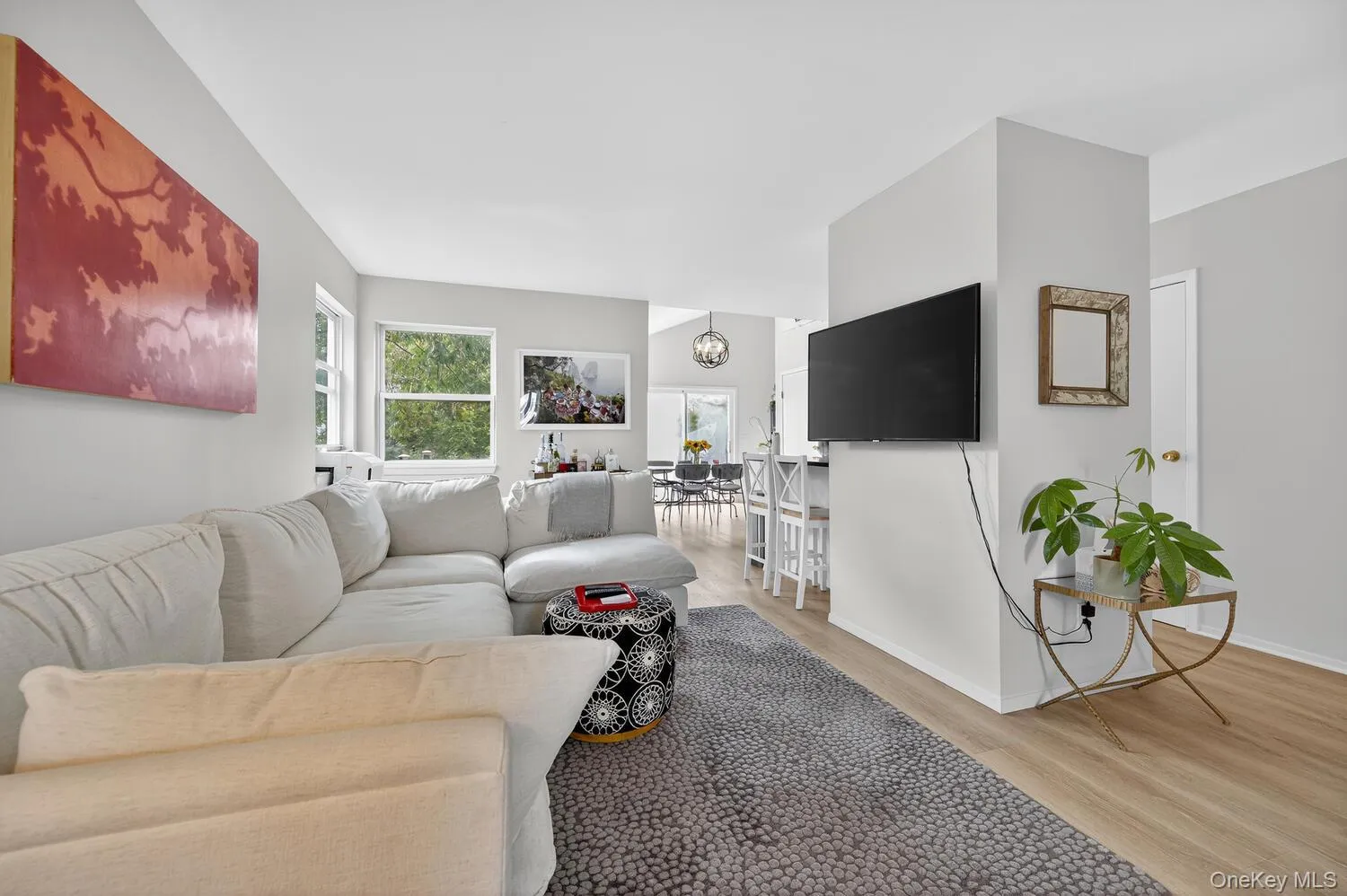 Living room featuring light wood-style floors and a chandelier Living room featuring light wood-style floors and a chandelier
