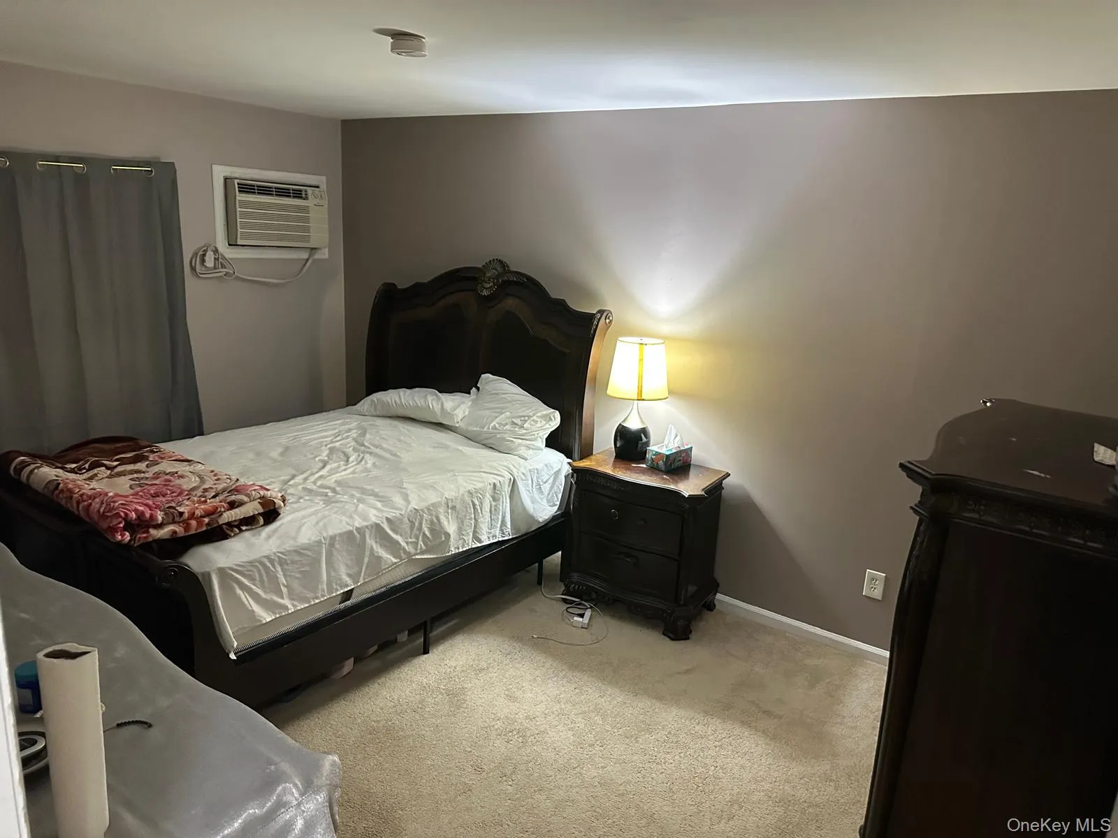 Bedroom with light carpet and an AC wall unit Bedroom with light carpet and an AC wall unit
