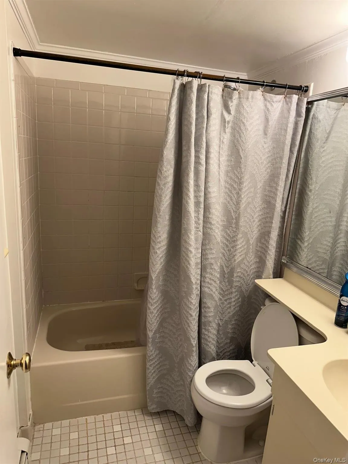 Bathroom with vanity, light tile patterned floors, shower / bath combination with curtain, and crown molding Bathroom with vanity, light tile patterned floors, shower / bath combination with curtain, and crown molding