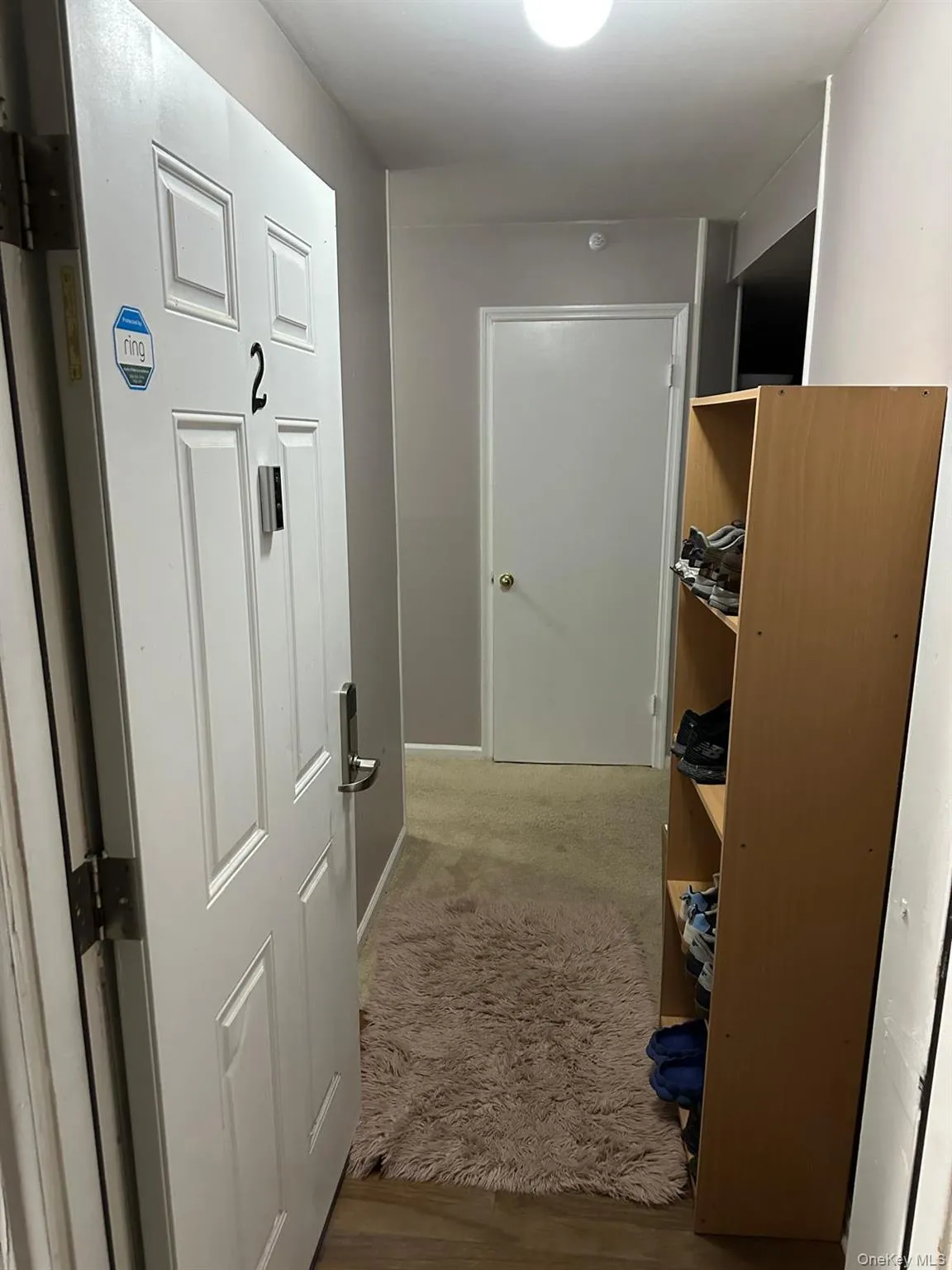 Hall featuring light carpet and light wood-style flooring Hall featuring light carpet and light wood-style flooring