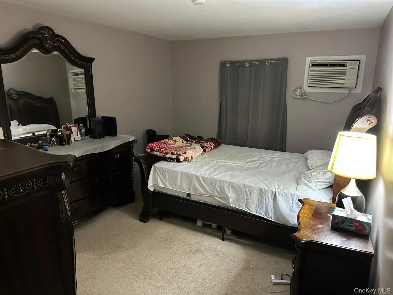 Bedroom featuring light carpet and a wall unit AC Bedroom featuring light carpet and a wall unit AC