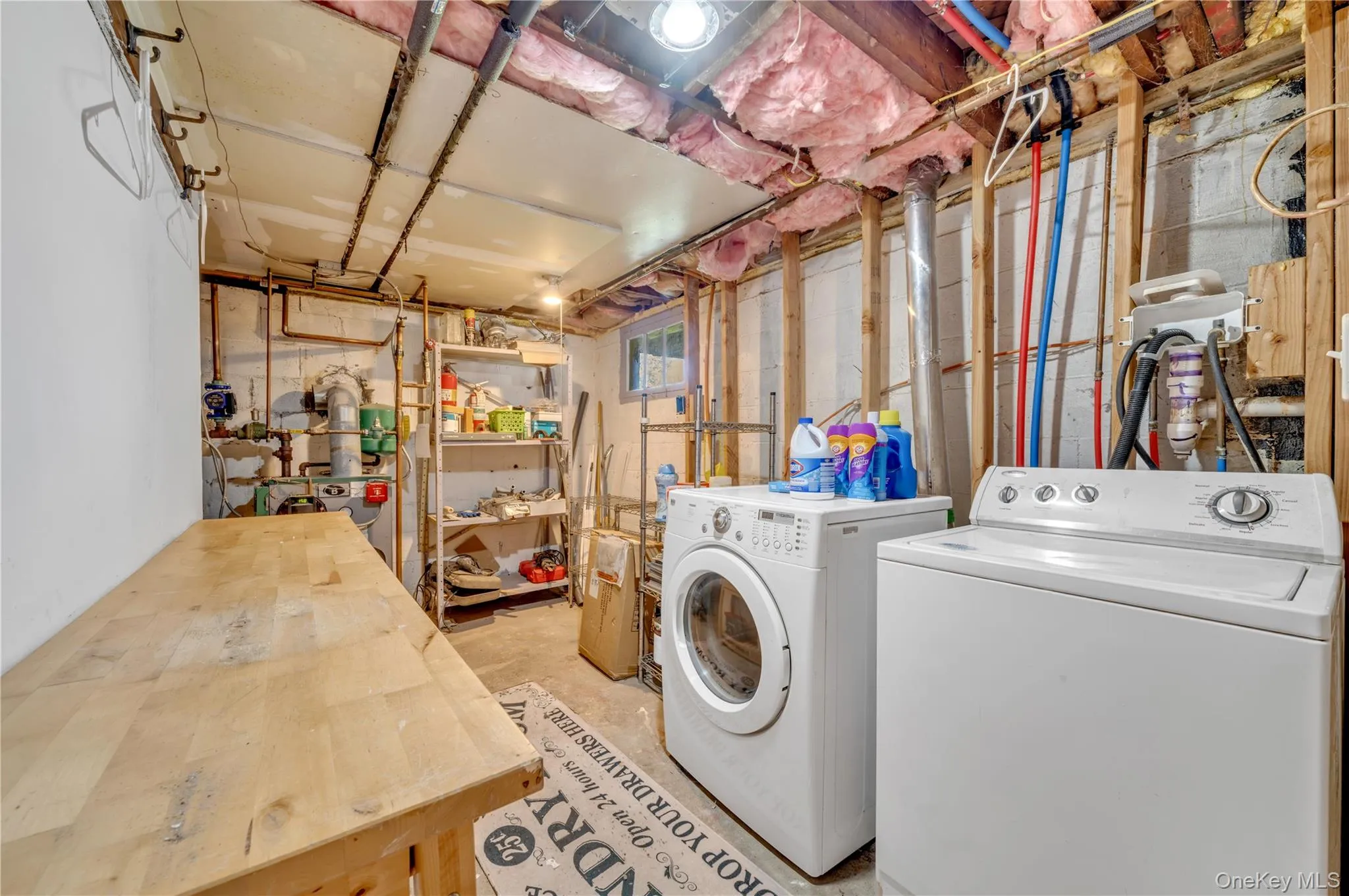 Laundry room featuring unfinished concrete flooring and washing machine and clothes dryer Laundry room featuring unfinished concrete flooring and washing machine and clothes dryer