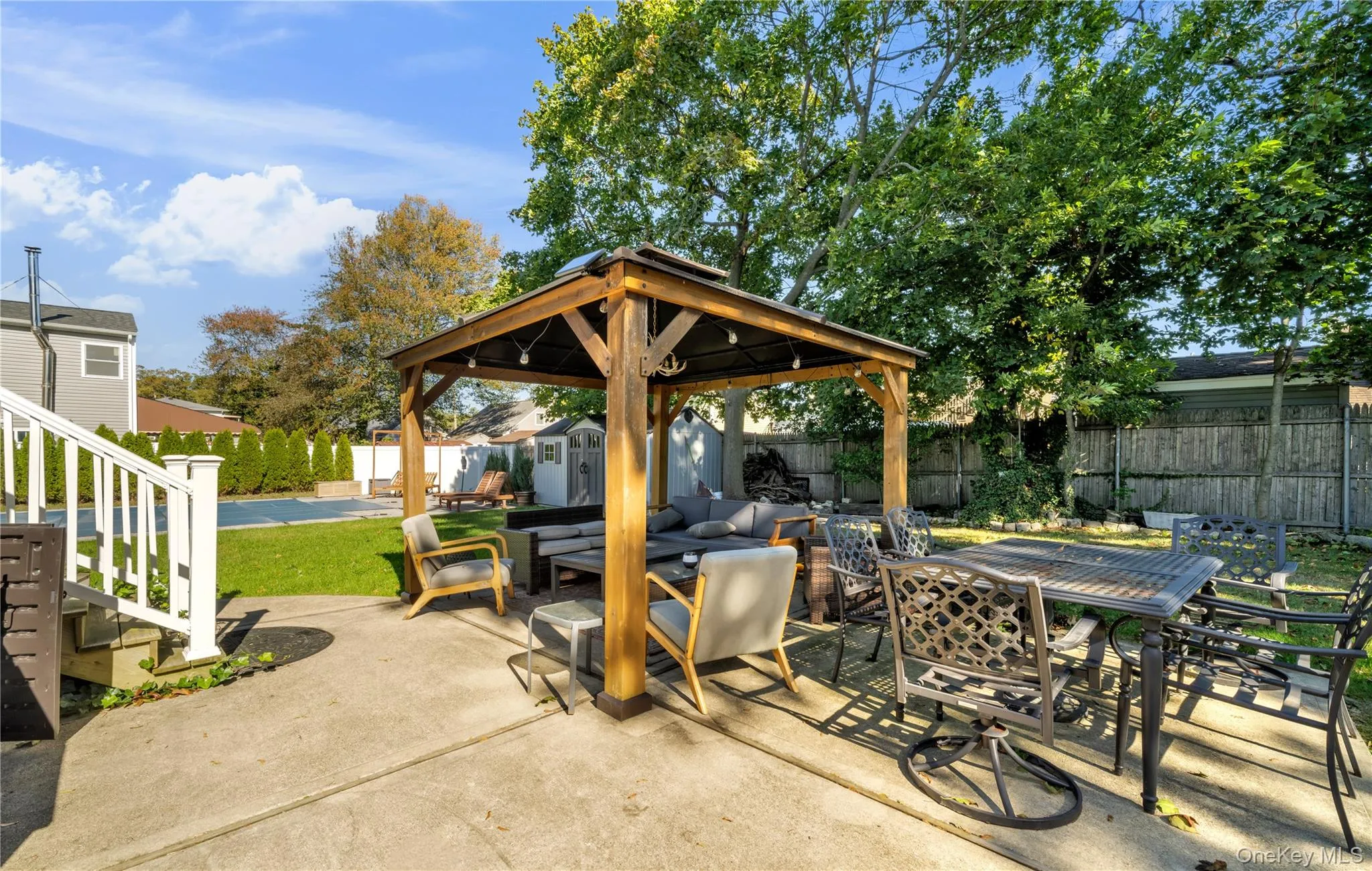 Fenced backyard with outdoor dining area, a shed, a patio, and a gazebo Fenced backyard with outdoor dining area, a shed, a patio, and a gazebo