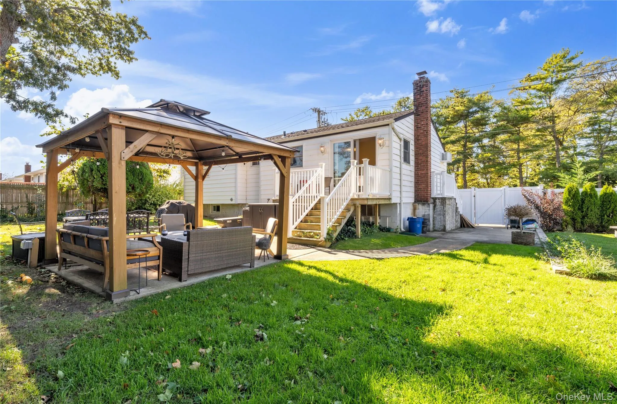 Rear view of property with a fenced backyard, outdoor lounge area, a gate, a patio area, and a gazebo Rear view of property with a fenced backyard, outdoor lounge area, a gate, a patio area, and a gazebo