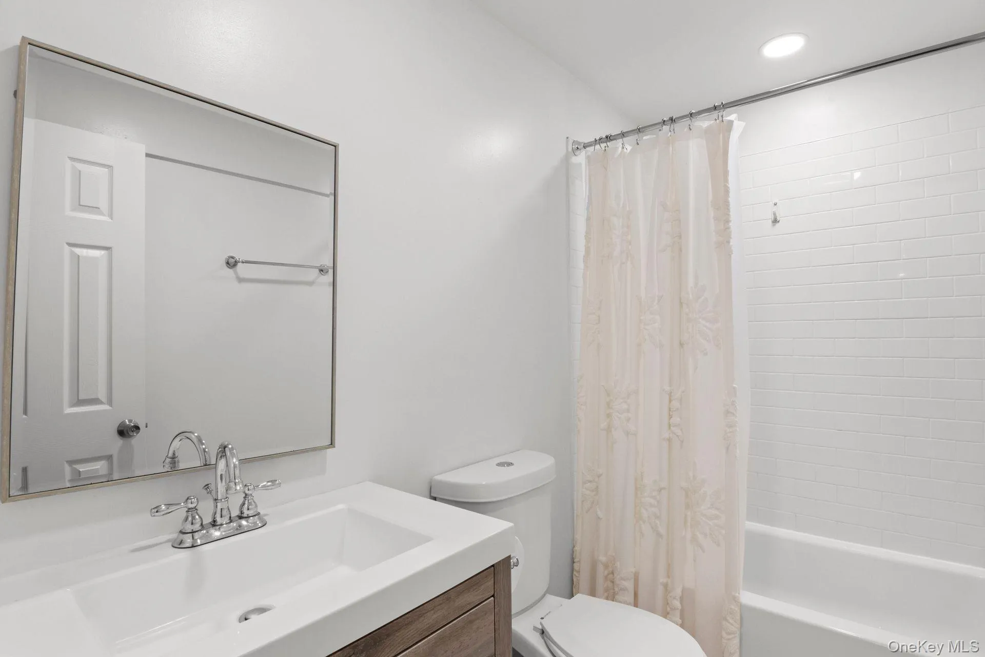 LOWER LEVEL Bathroom with shower / tub combo with curtain, vanity, and recessed lighting LOWER LEVEL Bathroom with shower / tub combo with curtain, vanity, and recessed lighting