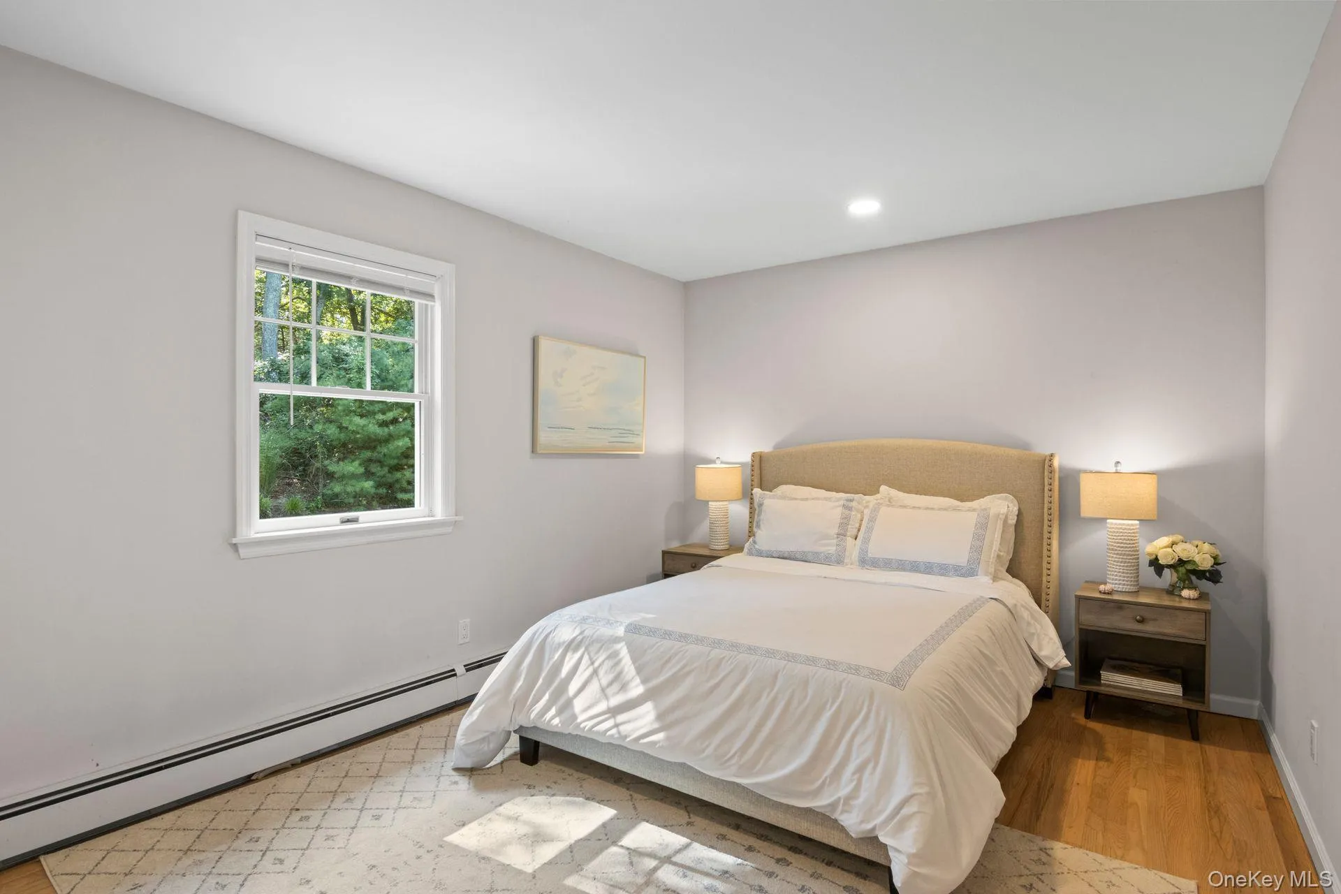 Bedroom with baseboard heating, light wood-type flooring, and recessed lighting Bedroom with baseboard heating, light wood-type flooring, and recessed lighting