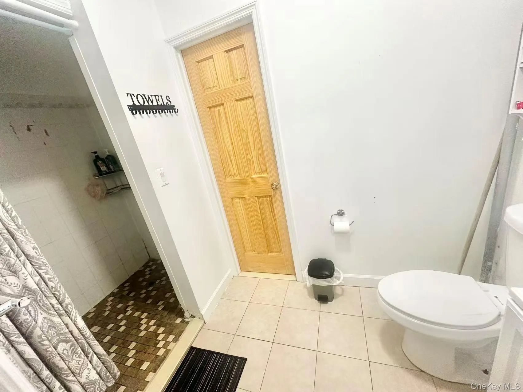 Bathroom featuring light tile patterned floors and a stall shower Bathroom featuring light tile patterned floors and a stall shower