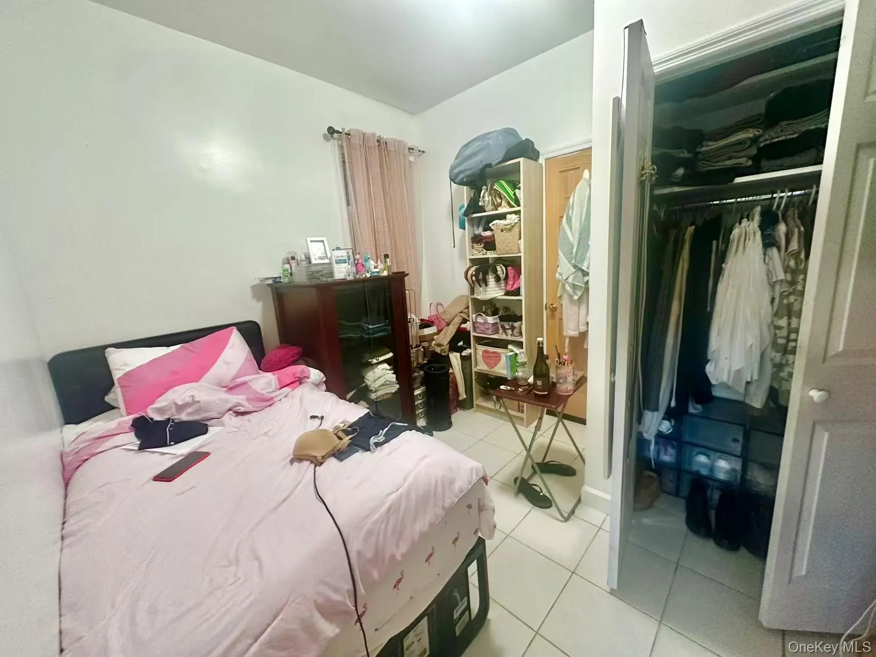 Bedroom featuring a closet and light tile patterned flooring Bedroom featuring a closet and light tile patterned flooring