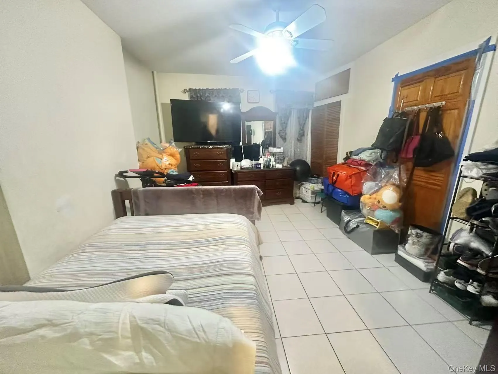Bedroom featuring light tile patterned floors, ceiling fan, and a closet Bedroom featuring light tile patterned floors, ceiling fan, and a closet