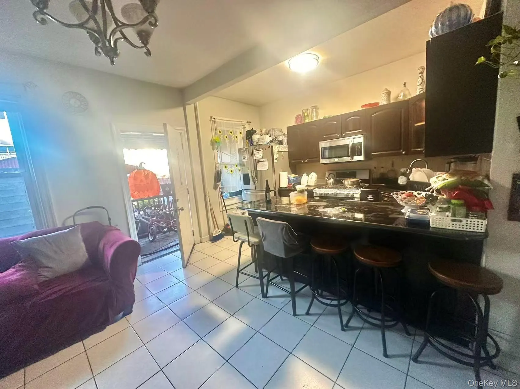 Kitchen featuring a kitchen breakfast bar, appliances with stainless steel finishes, light tile patterned flooring, a peninsula, and open floor plan Kitchen featuring a kitchen breakfast bar, appliances with stainless steel finishes, light tile patterned flooring, a peninsula, and open floor plan