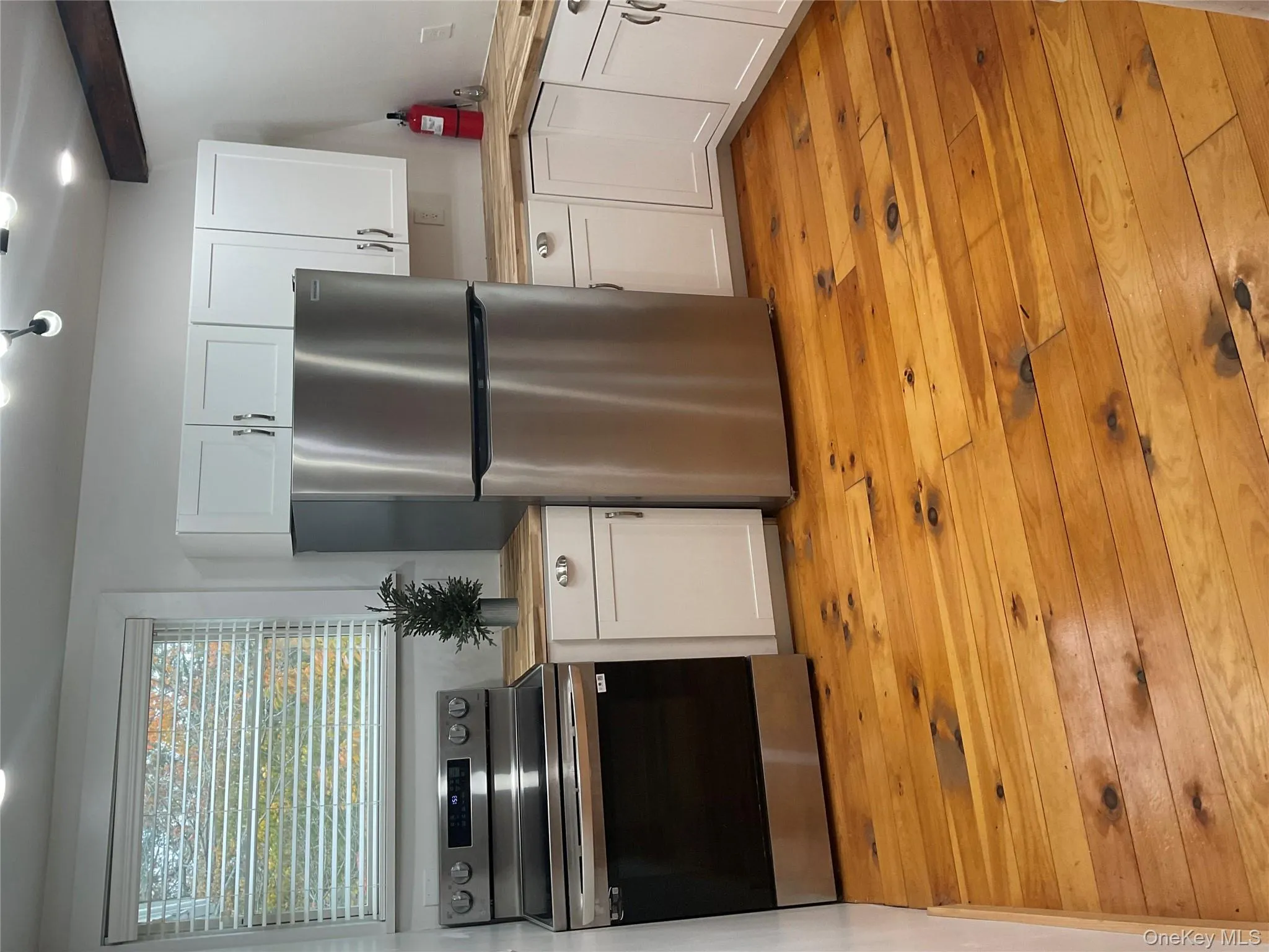 Kitchen with butcher block counters, stainless steel appliances, white cabinets, and light wood-style floors Kitchen with butcher block counters, stainless steel appliances, white cabinets, and light wood-style floors