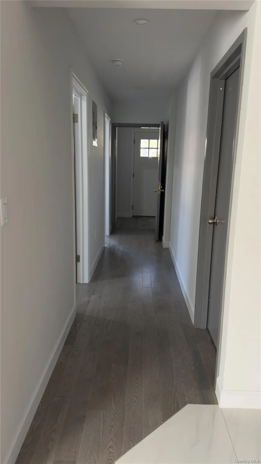 Hall featuring dark wood-style floors and baseboards Hall featuring dark wood-style floors and baseboards