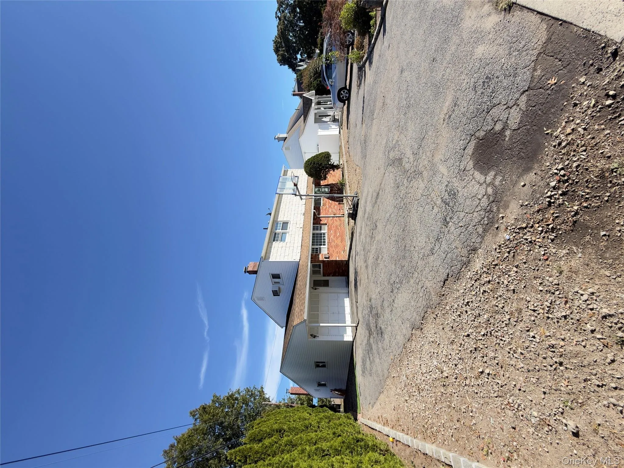 View of front of property featuring brick siding, asphalt driveway, an attached garage, and a chimney View of front of property featuring brick siding, asphalt driveway, an attached garage, and a chimney