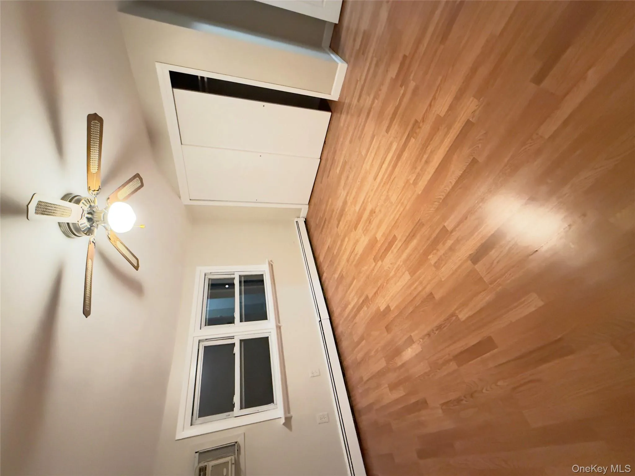 Unfurnished bedroom with a baseboard radiator, a ceiling fan, light wood-style flooring, and a closet Unfurnished bedroom with a baseboard radiator, a ceiling fan, light wood-style flooring, and a closet