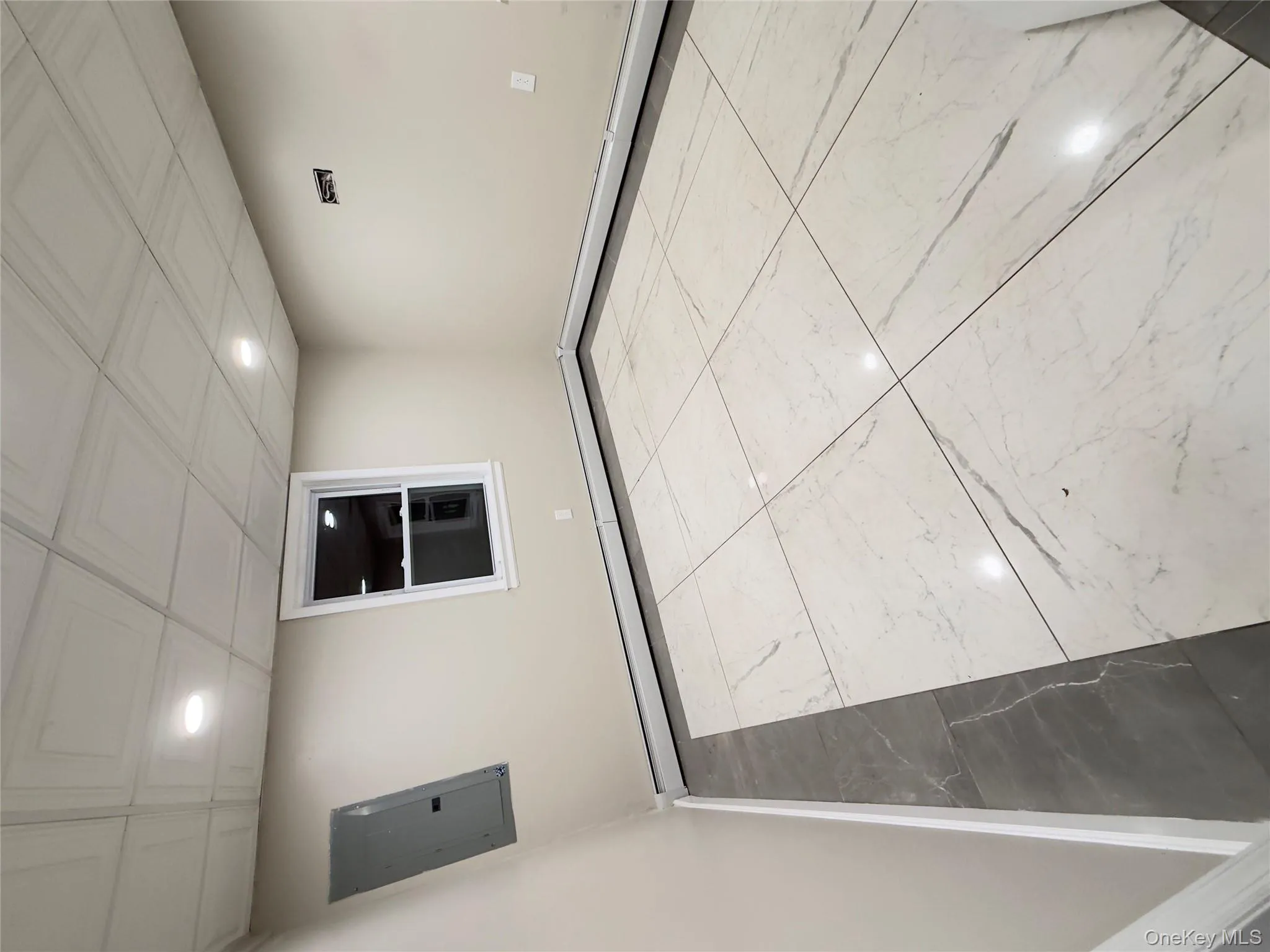 Unfurnished room with marble finish floors, electric panel, a baseboard radiator, and recessed lighting Unfurnished room with marble finish floors, electric panel, a baseboard radiator, and recessed lighting