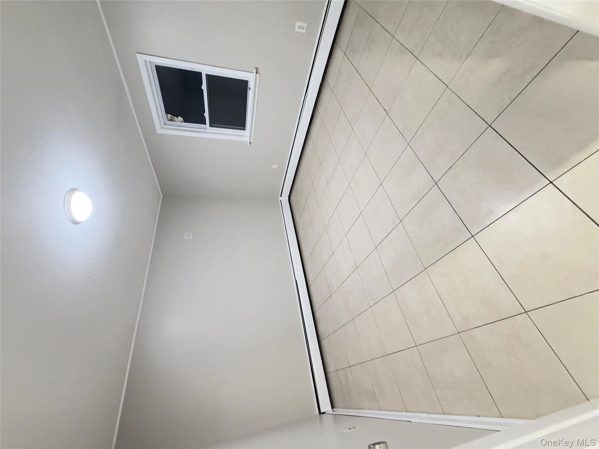 Unfurnished room featuring light tile patterned floors and a baseboard radiator Unfurnished room featuring light tile patterned floors and a baseboard radiator