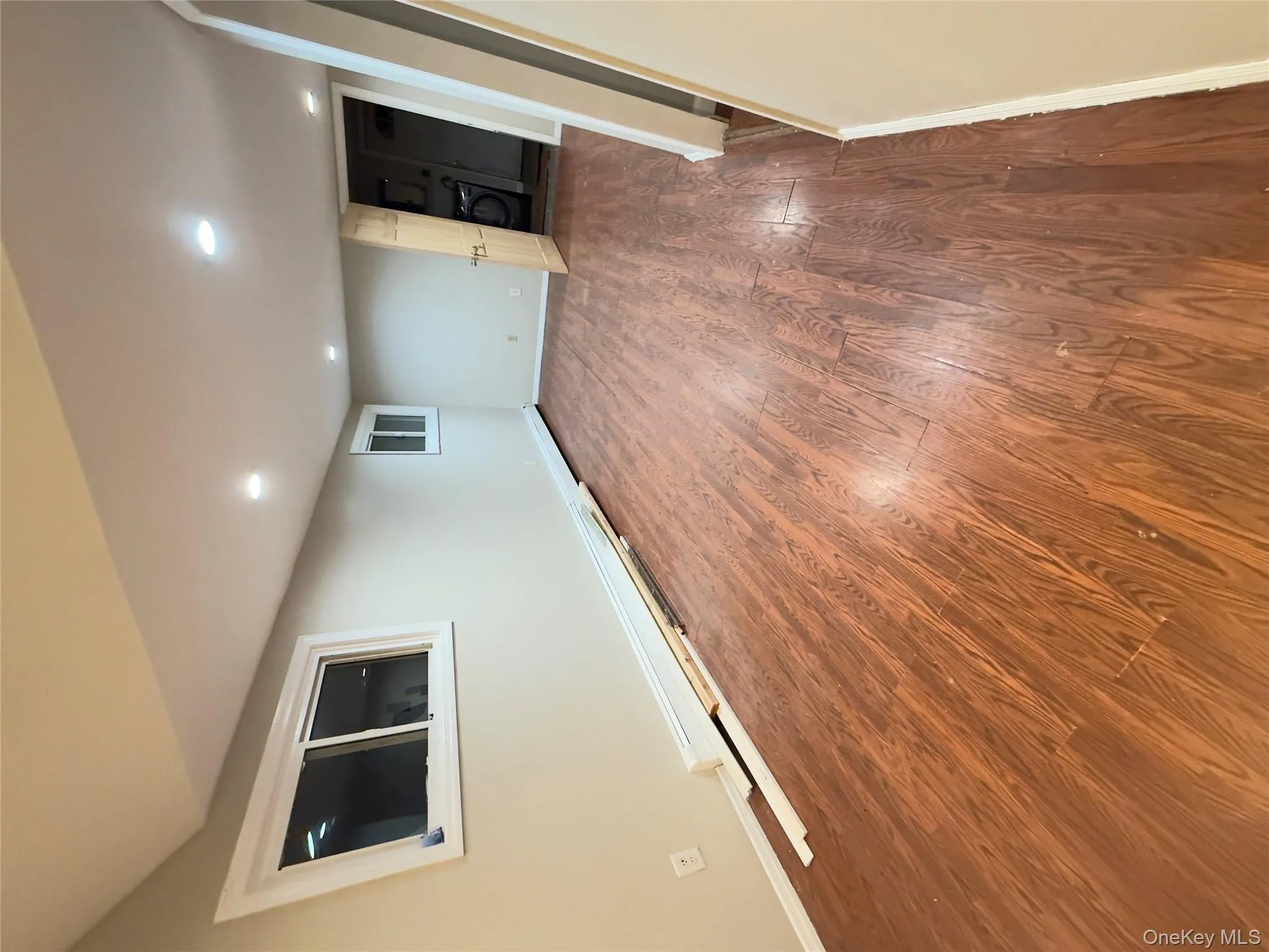 Finished below grade area featuring wood finished floors, a baseboard radiator, recessed lighting, and washer / dryer Finished below grade area featuring wood finished floors, a baseboard radiator, recessed lighting, and washer / dryer