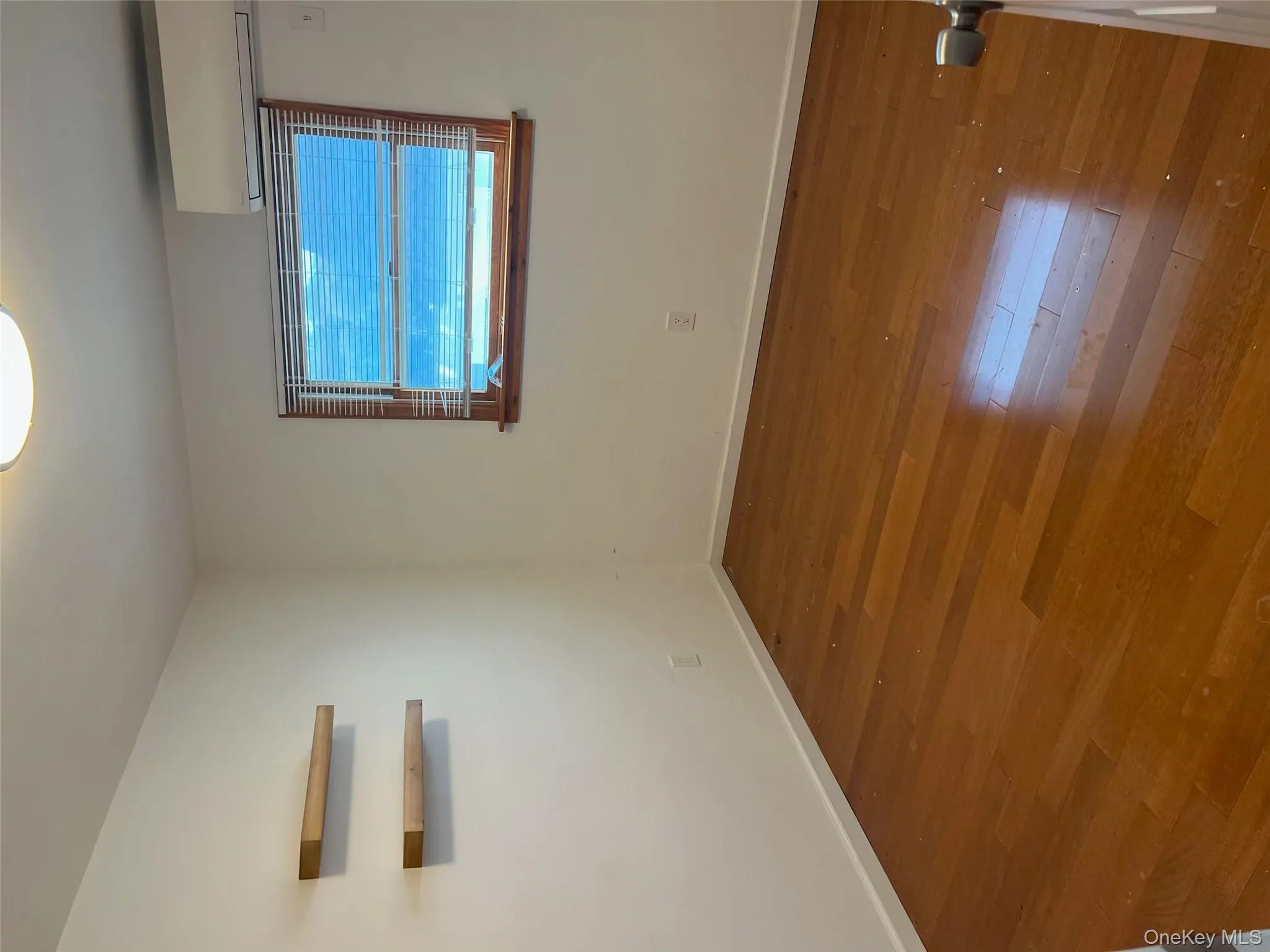 Unfurnished room featuring dark wood-style floors and a wall unit AC Unfurnished room featuring dark wood-style floors and a wall unit AC