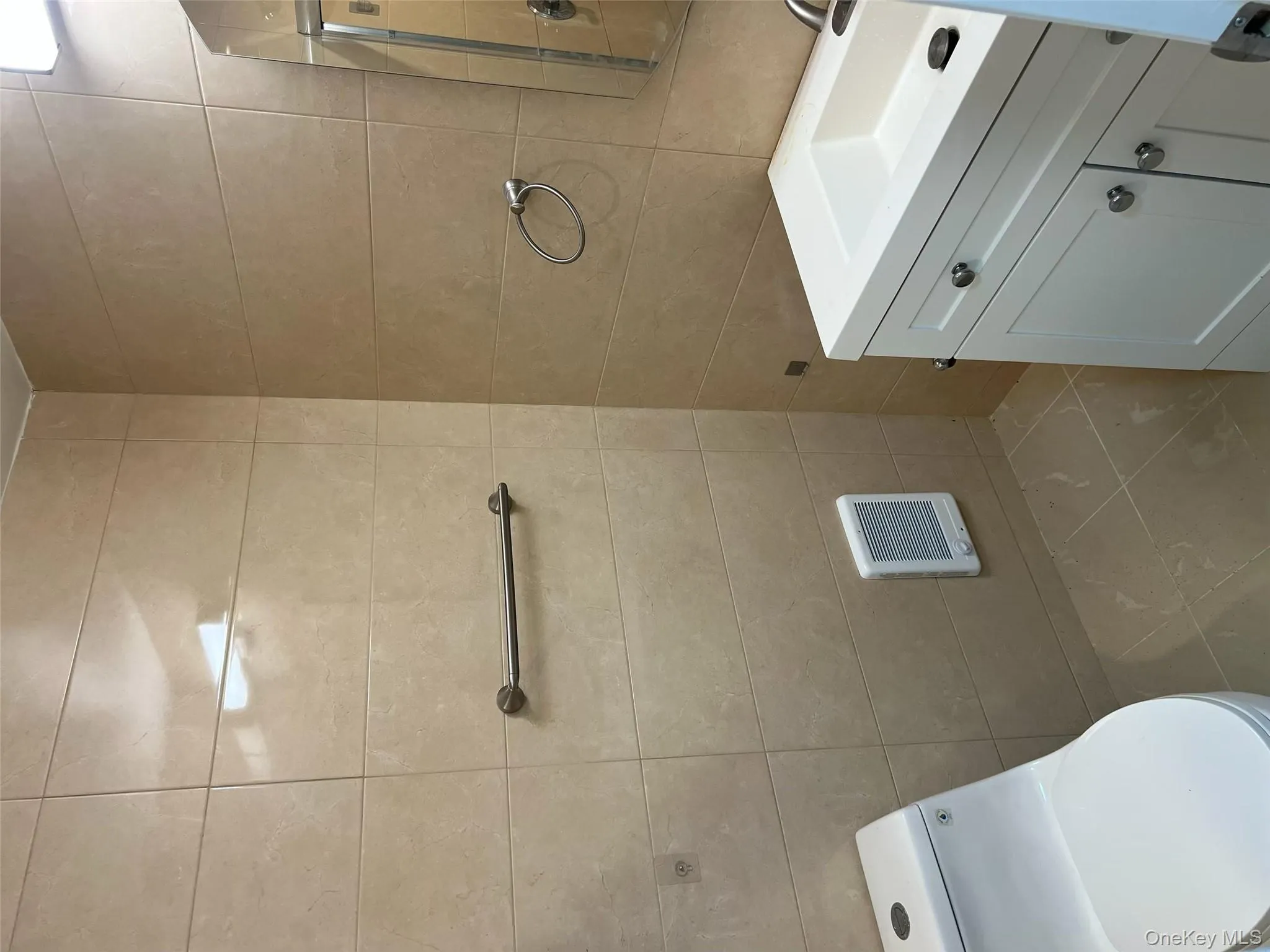 Half bathroom with vanity, tile walls, heating unit, and light tile patterned floors Half bathroom with vanity, tile walls, heating unit, and light tile patterned floors