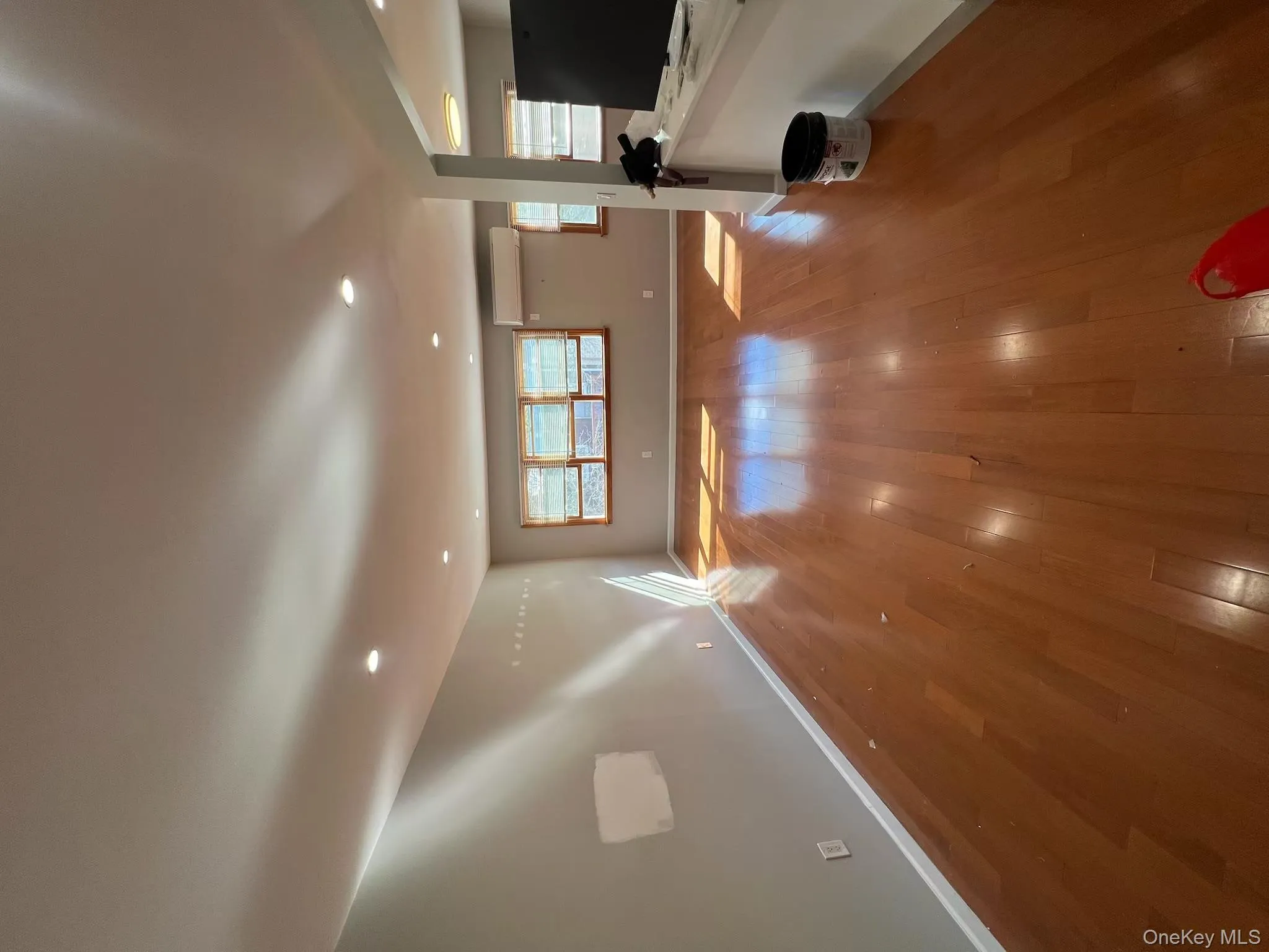 Unfurnished living room featuring hardwood / wood-style flooring, recessed lighting, and a wall mounted air conditioner Unfurnished living room featuring hardwood / wood-style flooring, recessed lighting, and a wall mounted air conditioner