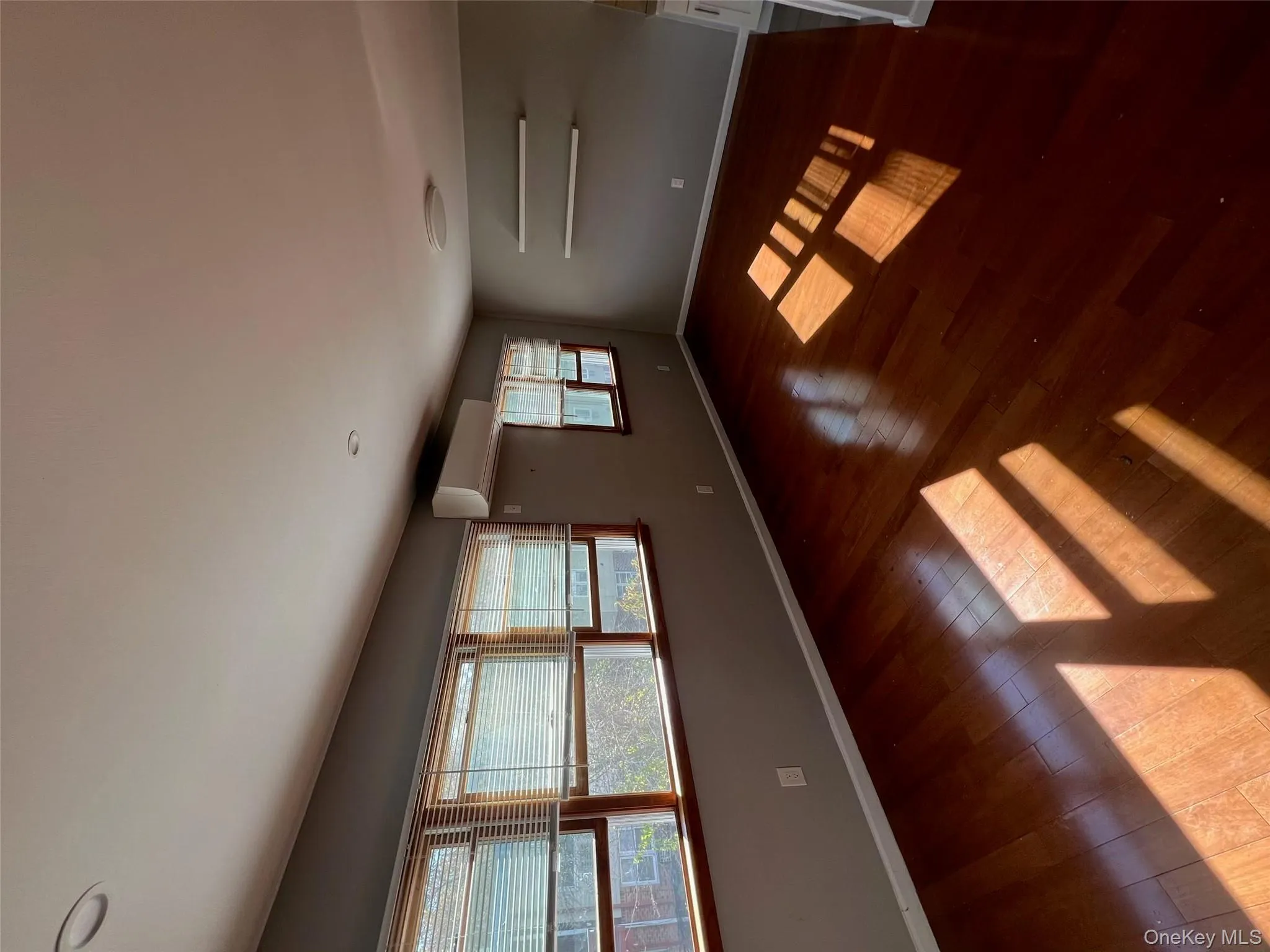 Unfurnished room with dark wood finished floors and a wall unit AC Unfurnished room with dark wood finished floors and a wall unit AC