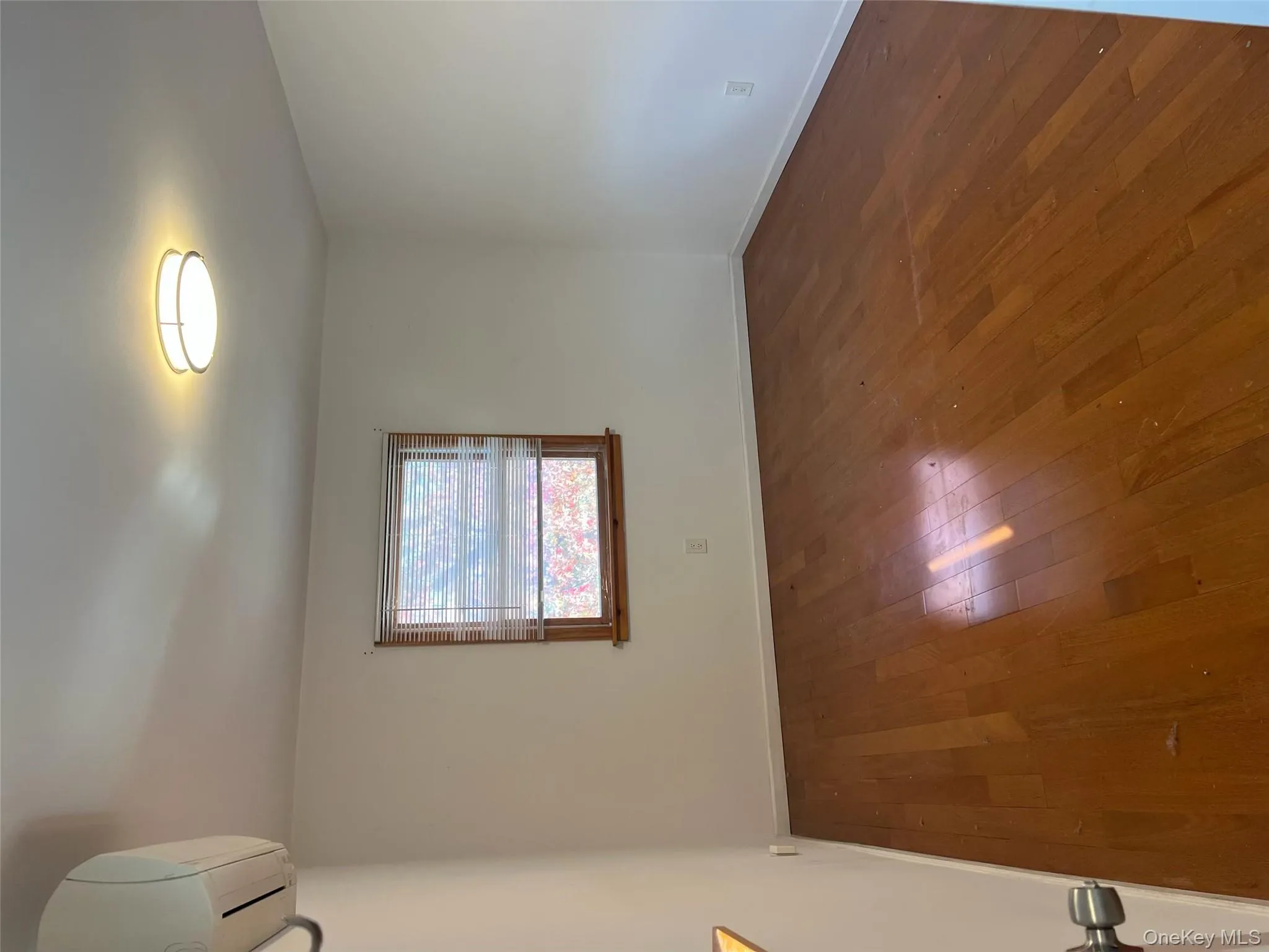 Empty room featuring dark wood-style floors and a wall unit AC Empty room featuring dark wood-style floors and a wall unit AC