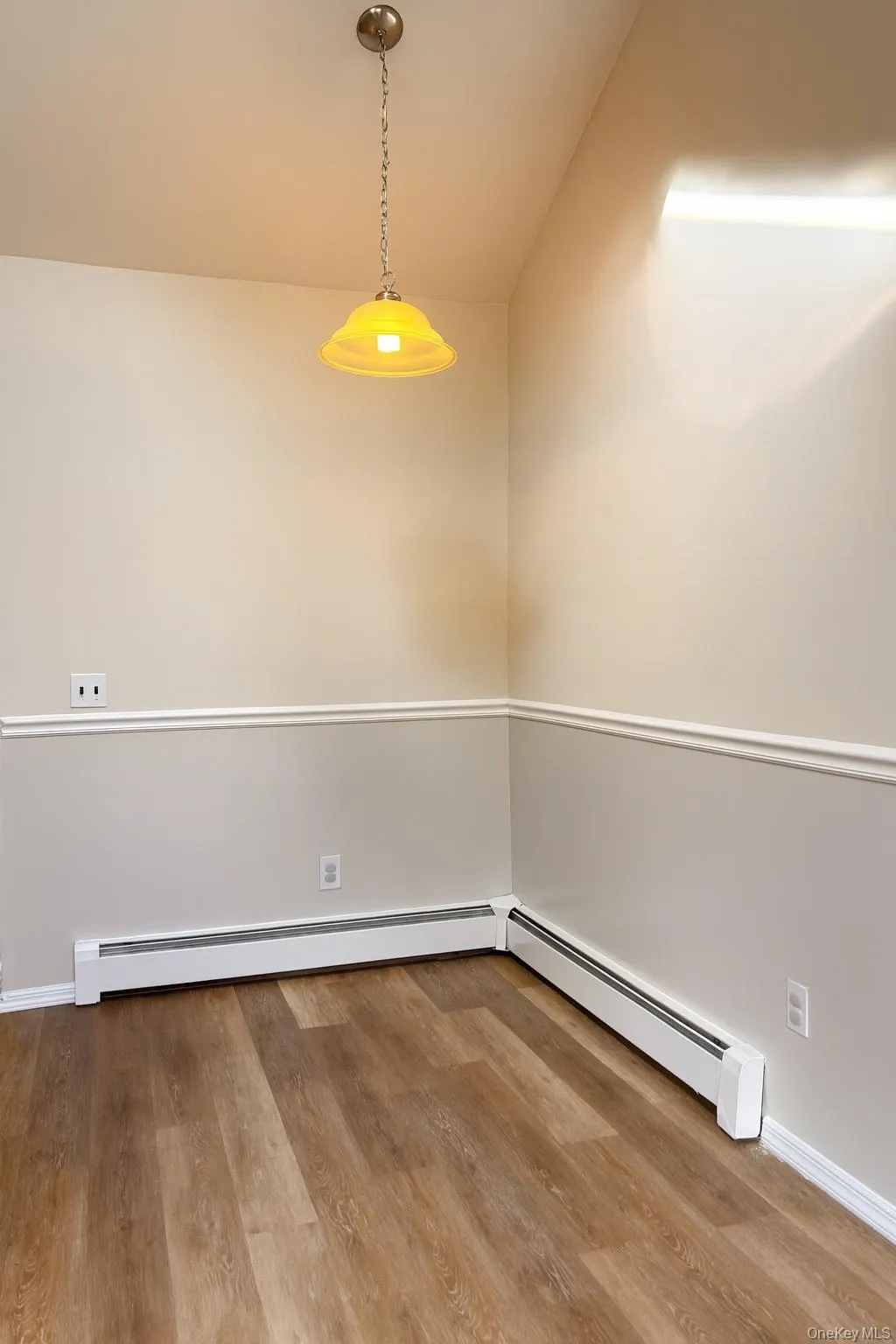 Unfurnished dining area featuring baseboard heating and light wood-type flooring Unfurnished dining area featuring baseboard heating and light wood-type flooring
