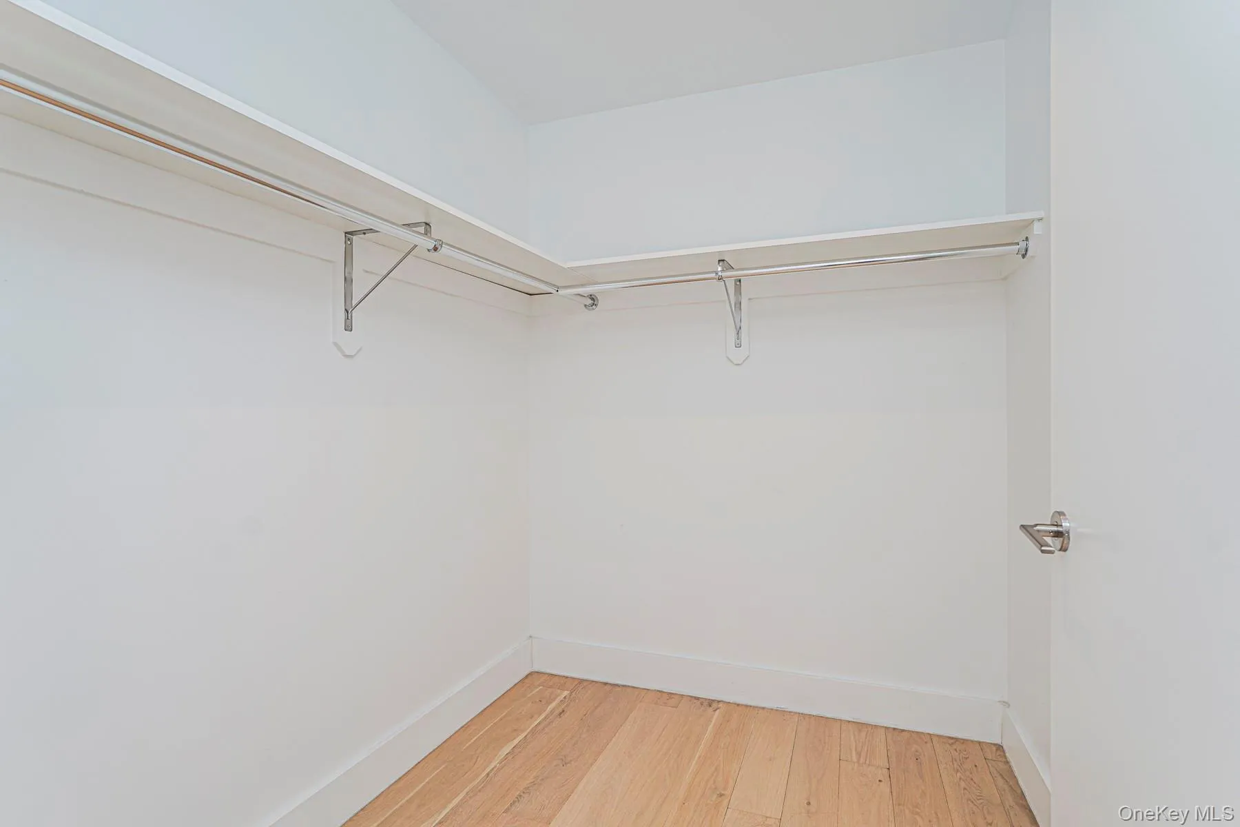 Walk in closet featuring light wood-style floors Walk in closet featuring light wood-style floors