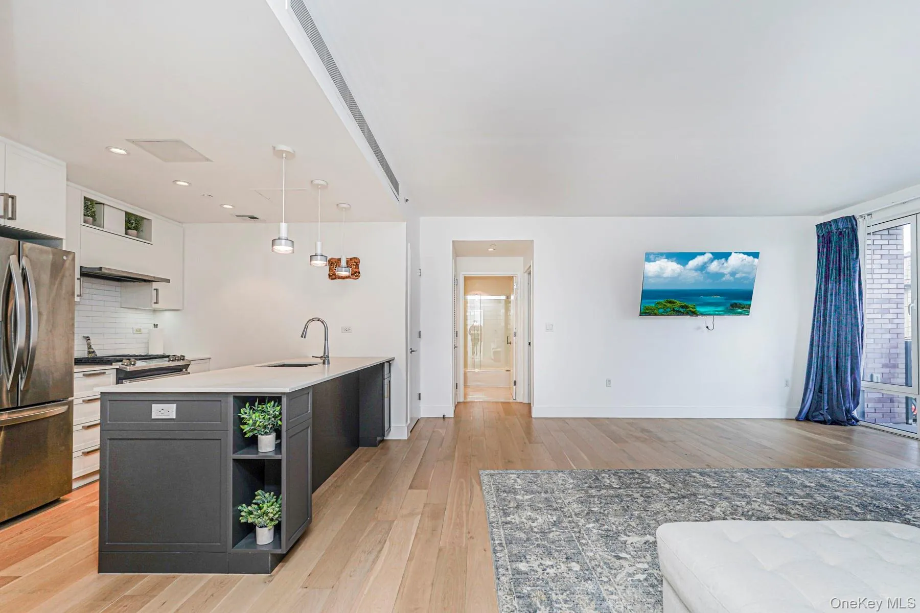 Kitchen featuring white cabinets, open shelves, hanging light fixtures, and light wood finished floors Kitchen featuring white cabinets, open shelves, hanging light fixtures, and light wood finished floors