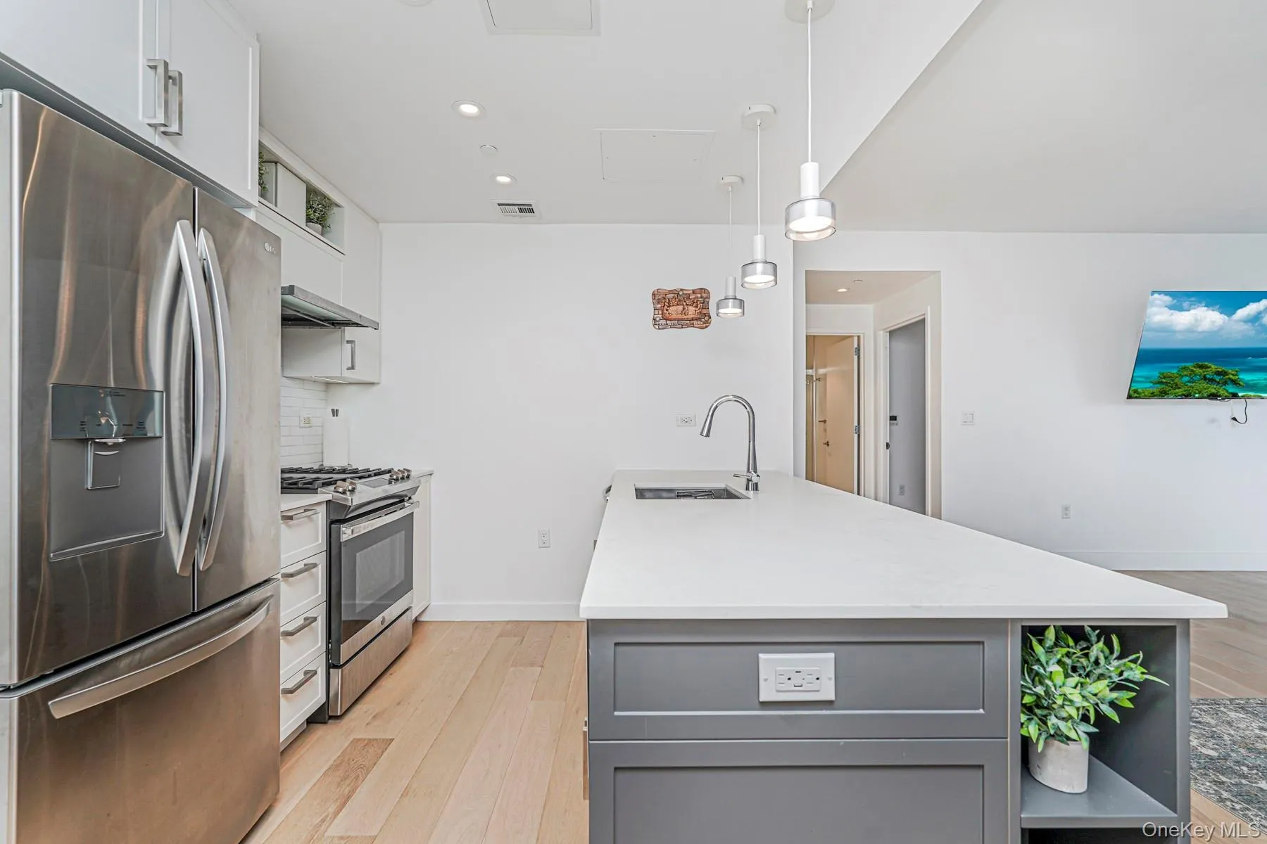 Kitchen featuring gray cabinets, white cabinets, appliances with stainless steel finishes, open shelves, and light wood-type flooring Kitchen featuring gray cabinets, white cabinets, appliances with stainless steel finishes, open shelves, and light wood-type flooring